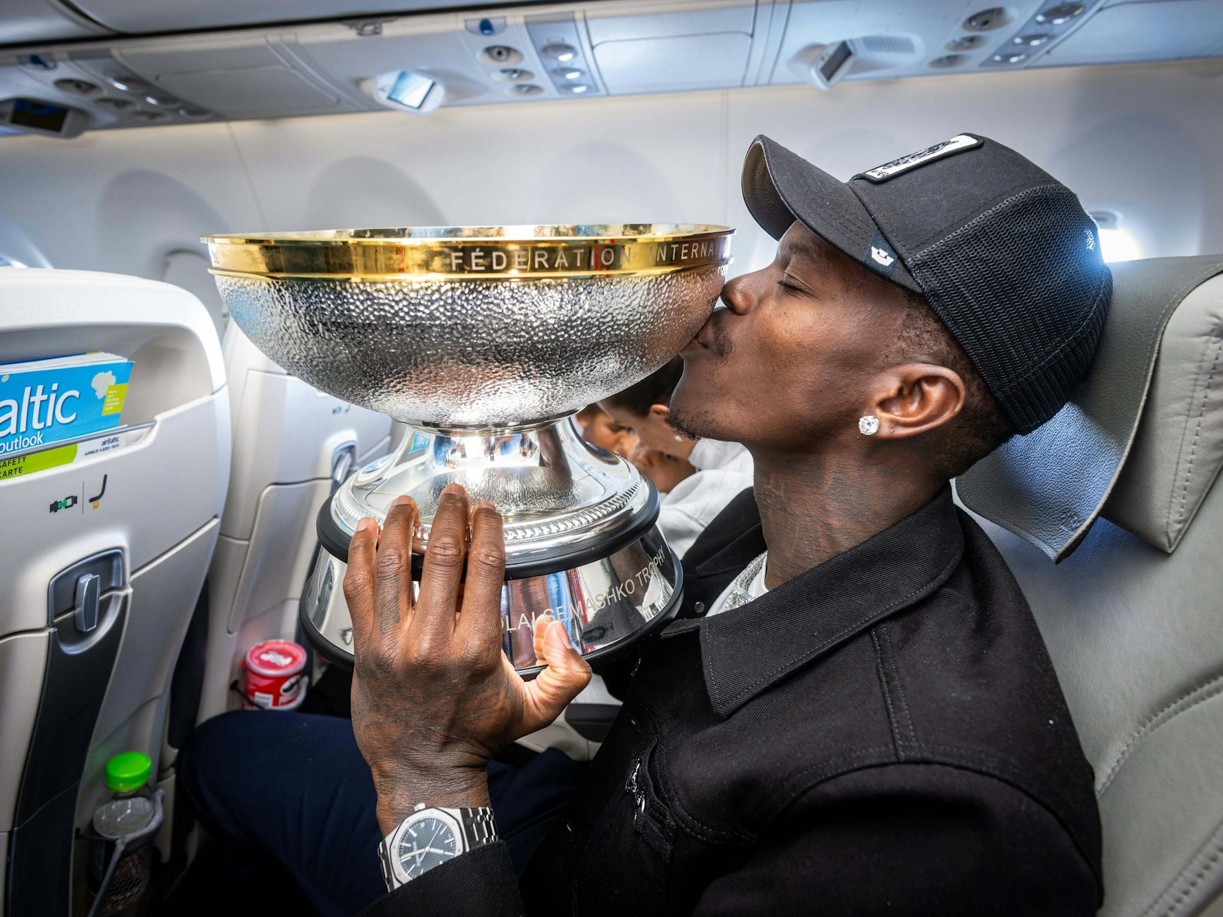 Dennis Schröder küsst im Flugzeug den EM-Pokal.