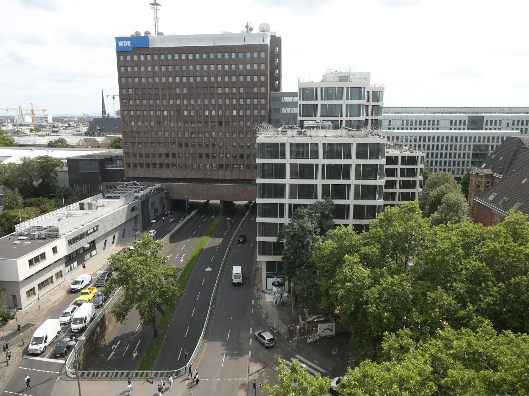 Ein Hochhaus mit einem WDR-Schild an der Fassade steht neben mehreren Hochhäusern.