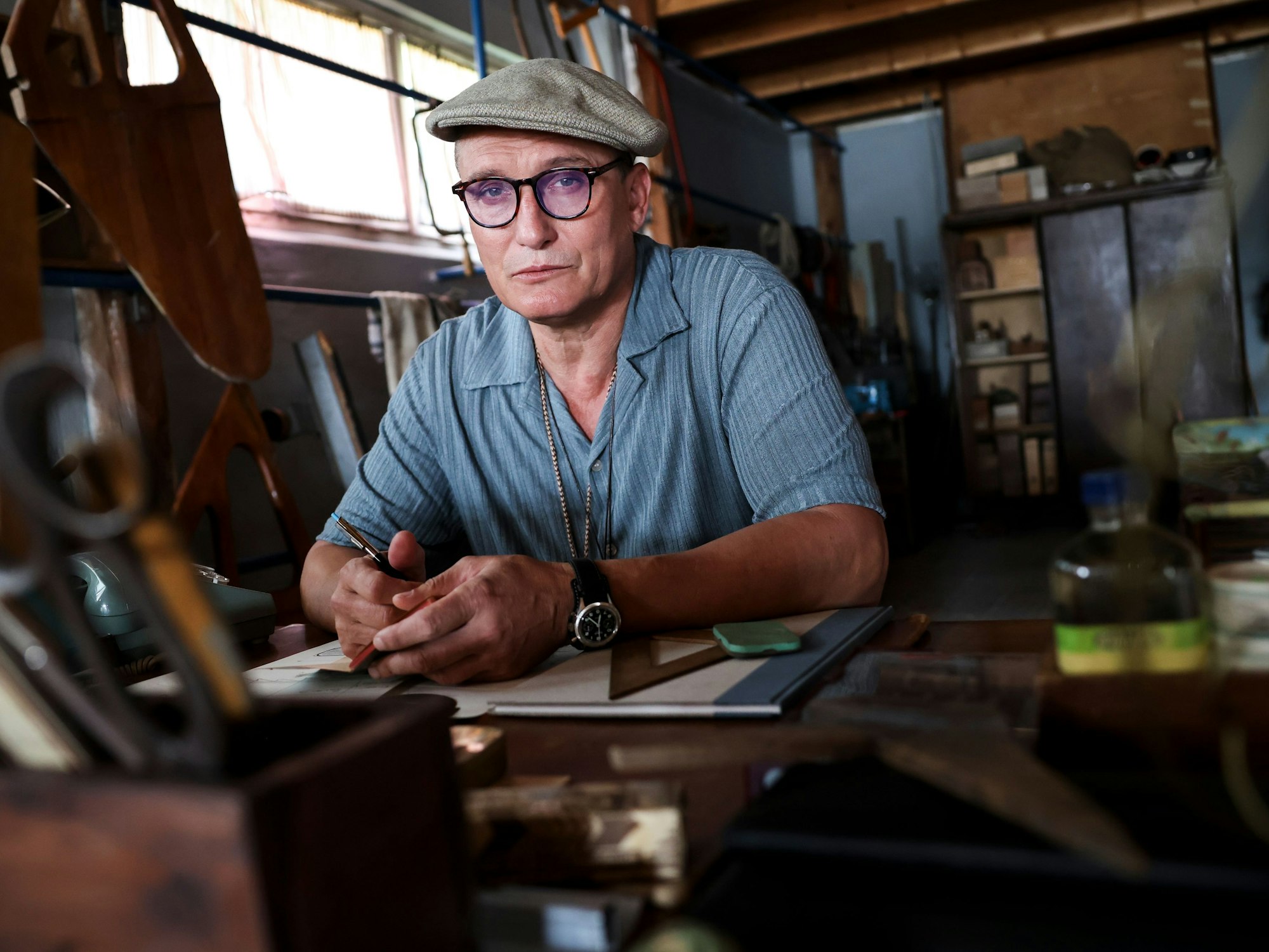 Oliver Masucci, Schauspieler in der Rolle als Rudertrainer Klaus Adam, sitzt am Set in seiner Werkstatt im Bootshaus des Ratzeburger Ruderclubs.