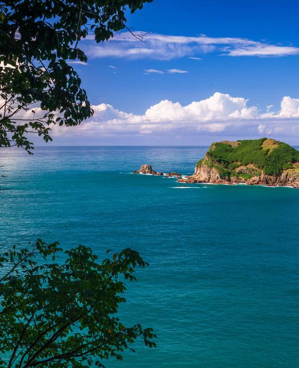 Blick auf eine Insel im Meer vom Aussichtspunkt Punta Serrucho bei Quepos in Costa Rica.