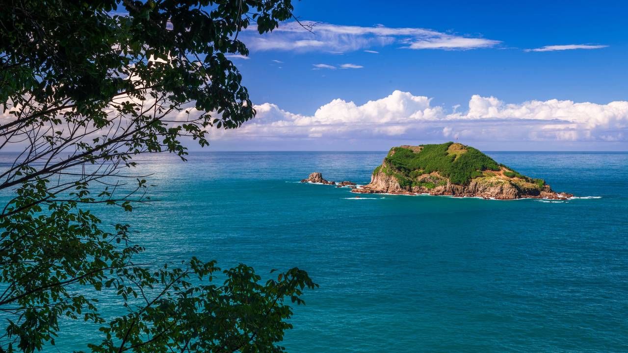 Blick auf eine Insel im Meer vom Aussichtspunkt Punta Serrucho bei Quepos in Costa Rica.