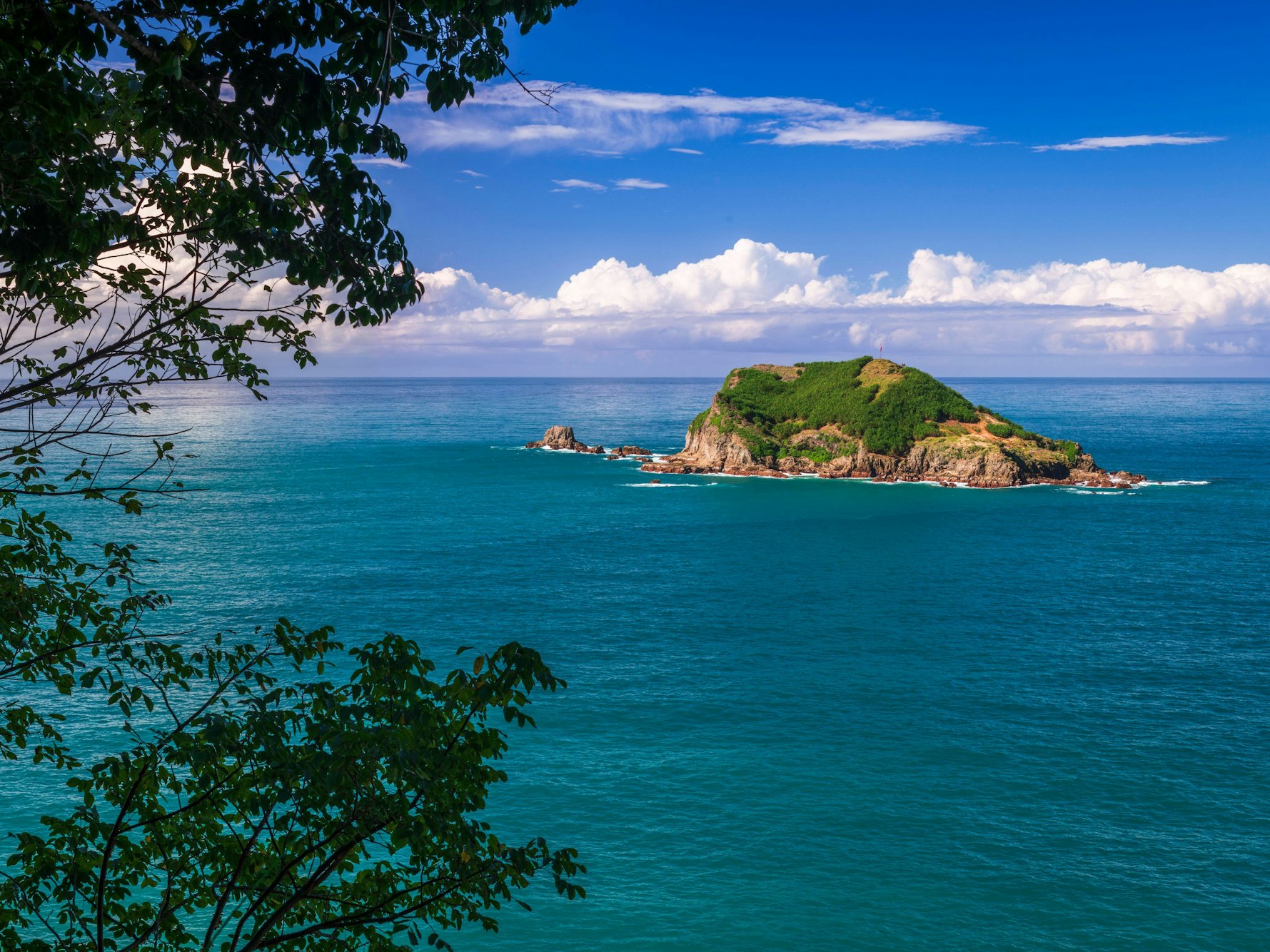 Blick auf eine Insel im Meer vom Aussichtspunkt Punta Serrucho bei Quepos in Costa Rica.