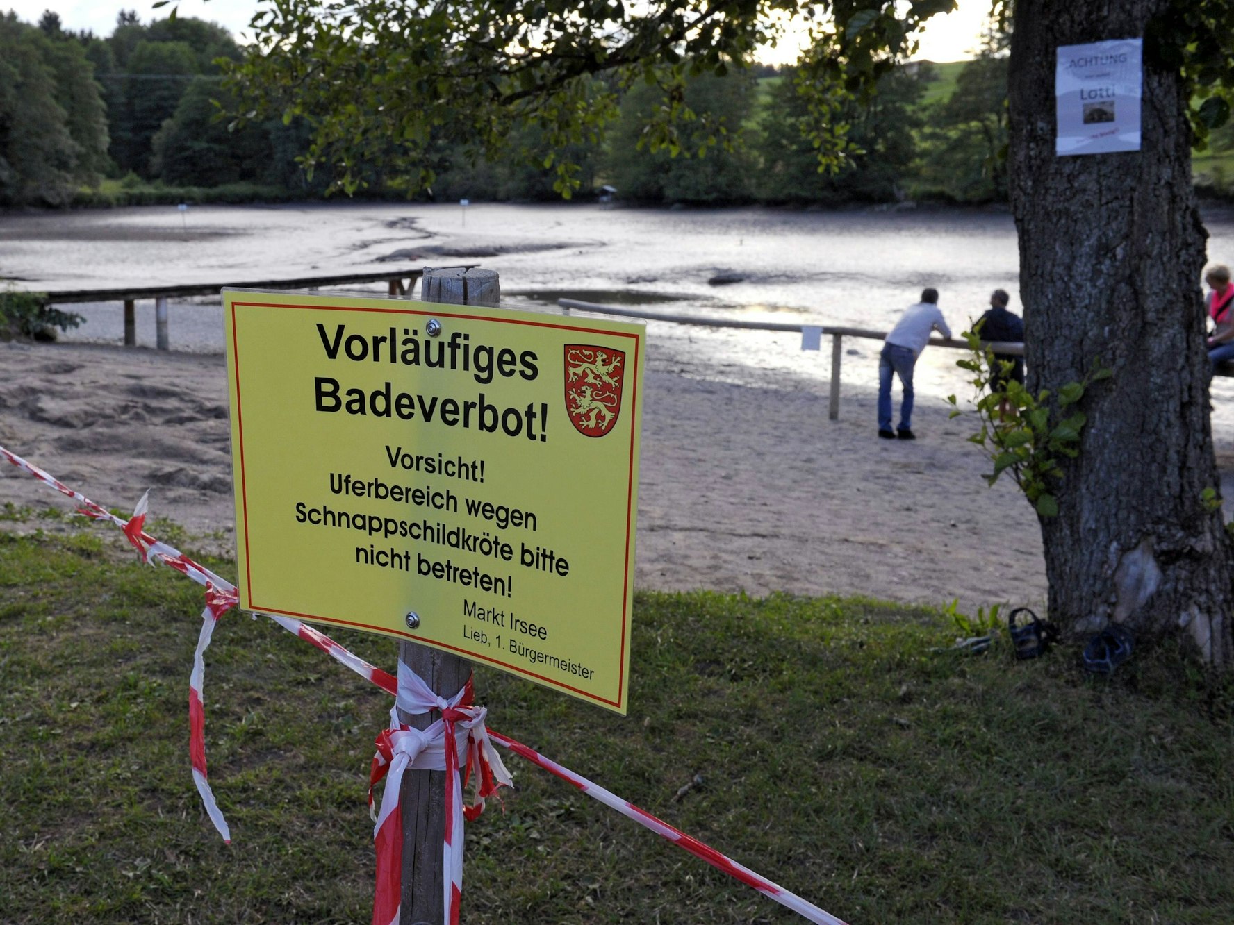 Ein Verbotsschild am Ufer eines Weihers, der für die Jagd auf eine Schildkröte leergepumpt wurde.