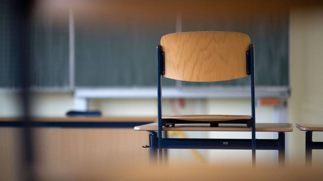 Ein Stuhl steht in einem Klassenzimmer auf einem Tisch.