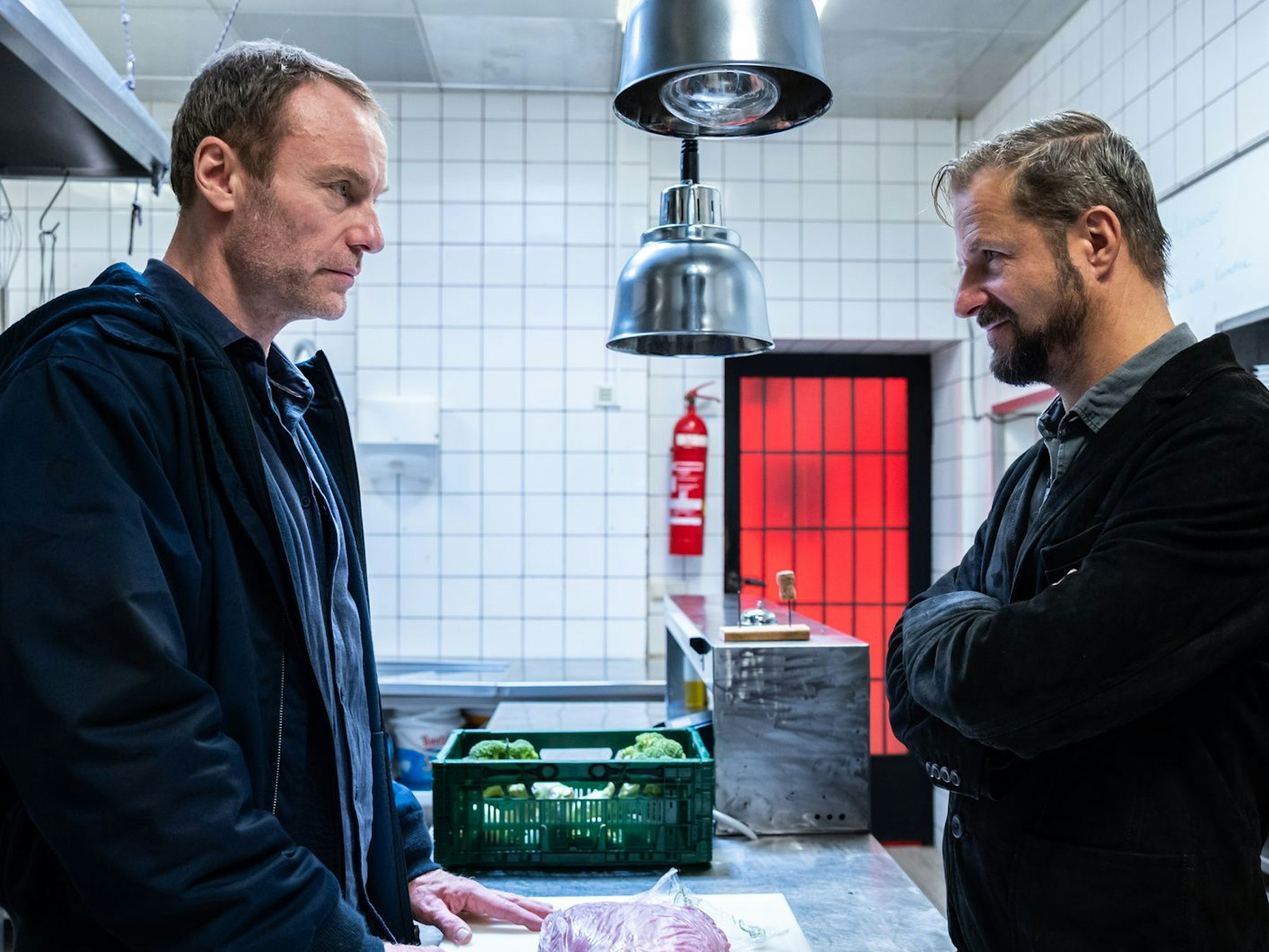 Zwei Männer stehen in einer Restaurantküche und unterhalten sich