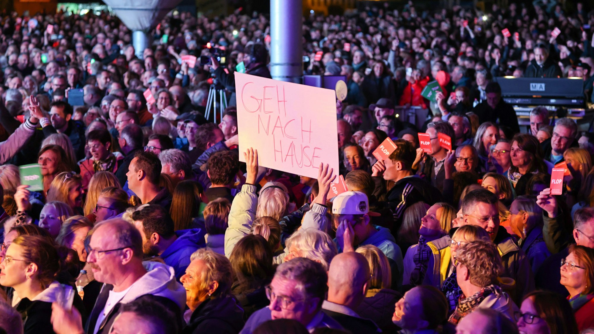 Ein Gast hält ein „Geh nach Hause“-Schild hoch.