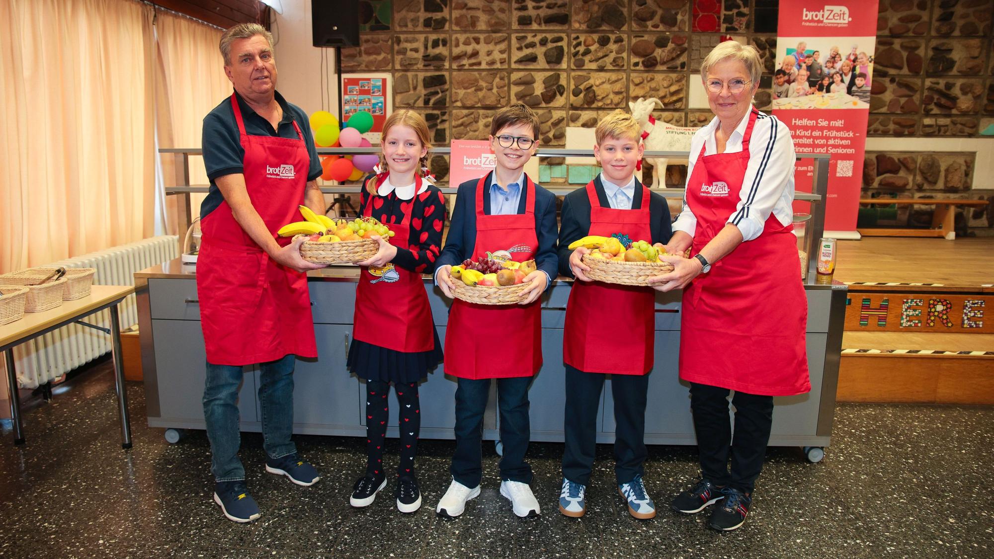 Das Kölner Kinderdreigestirn übergibt Obstkörbe.