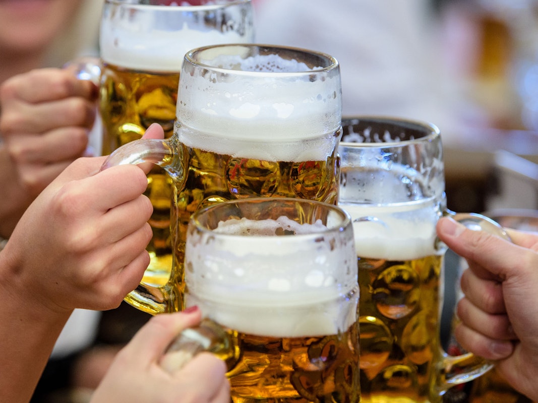 Besucher stoßen auf dem Münchner Oktoberfest mit Bier an