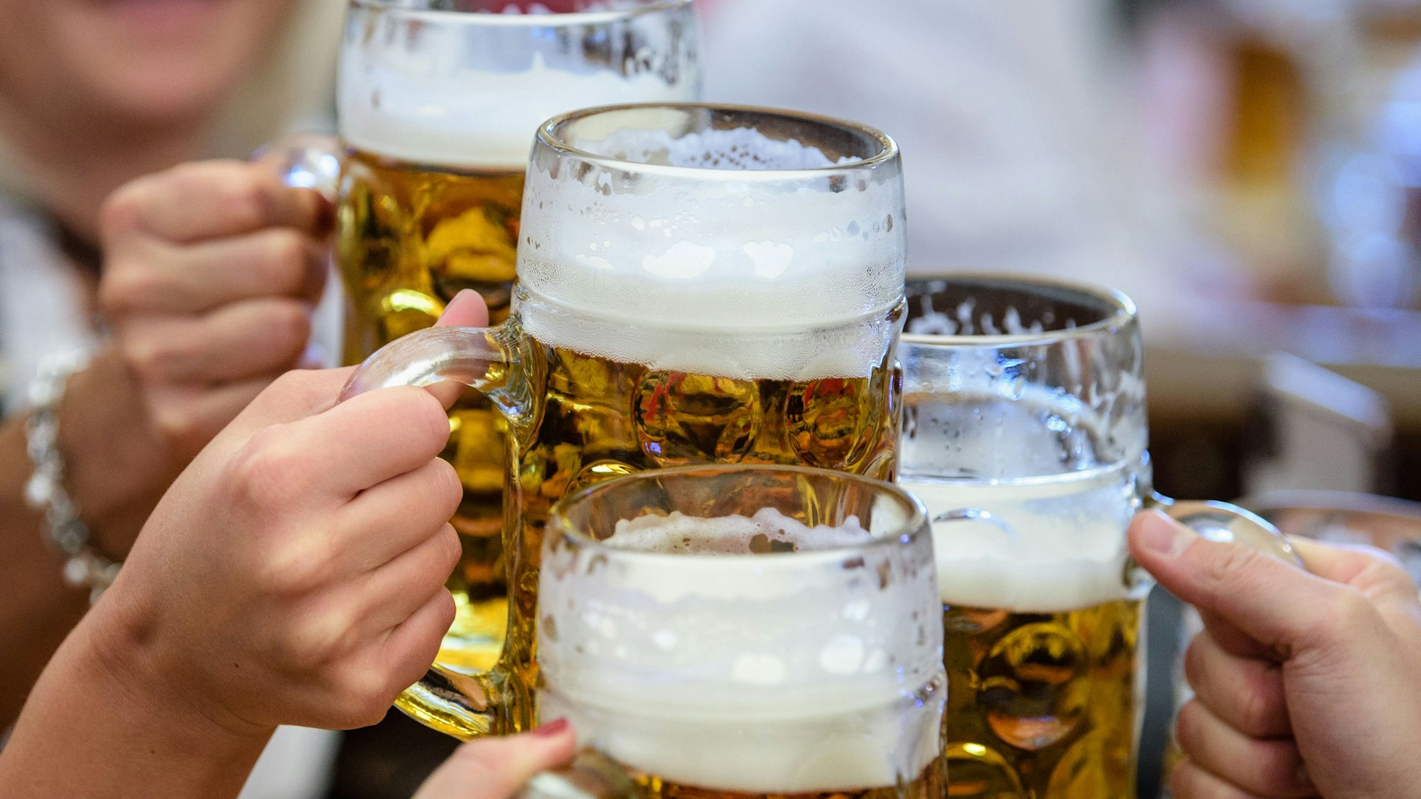 Besucher stoßen auf dem Münchner Oktoberfest mit Bier an