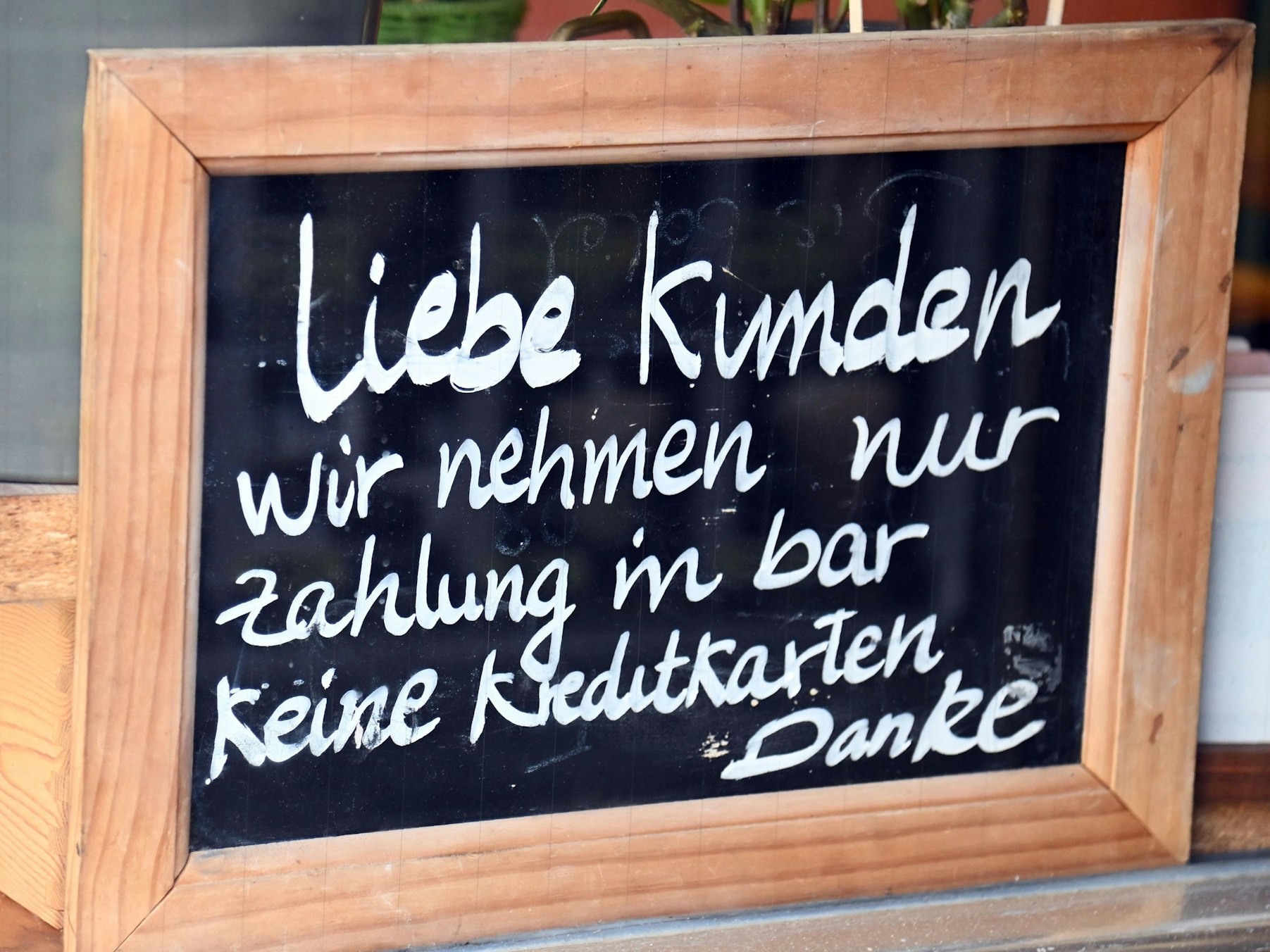 Ein Schild mit der Aufschrift: Liebe Kunden, wir nehmen nur Zahlung in bar, keine Kreditkarten.