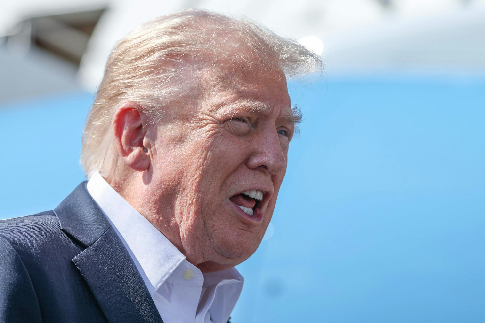 US-Präsident Donald Trump steigt rufend aus einem Flugzeug aus.