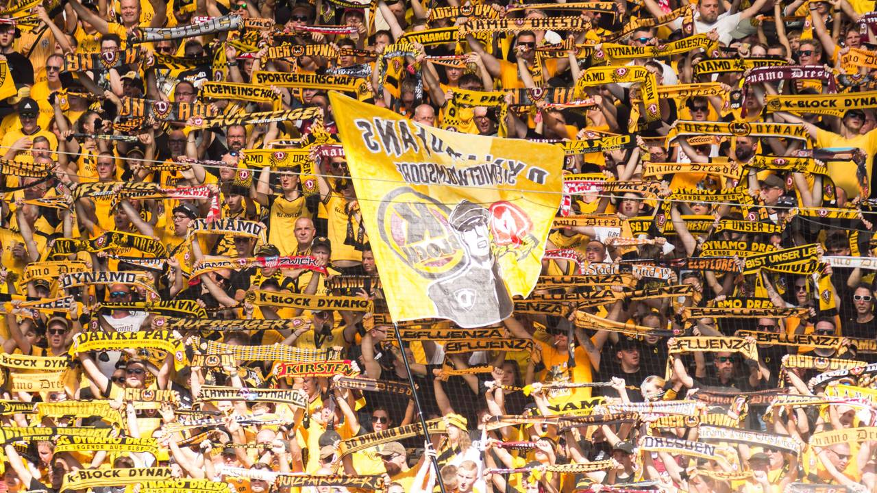 Dynamo-Fans halten im Gästeblock ihre Schals hoch.
