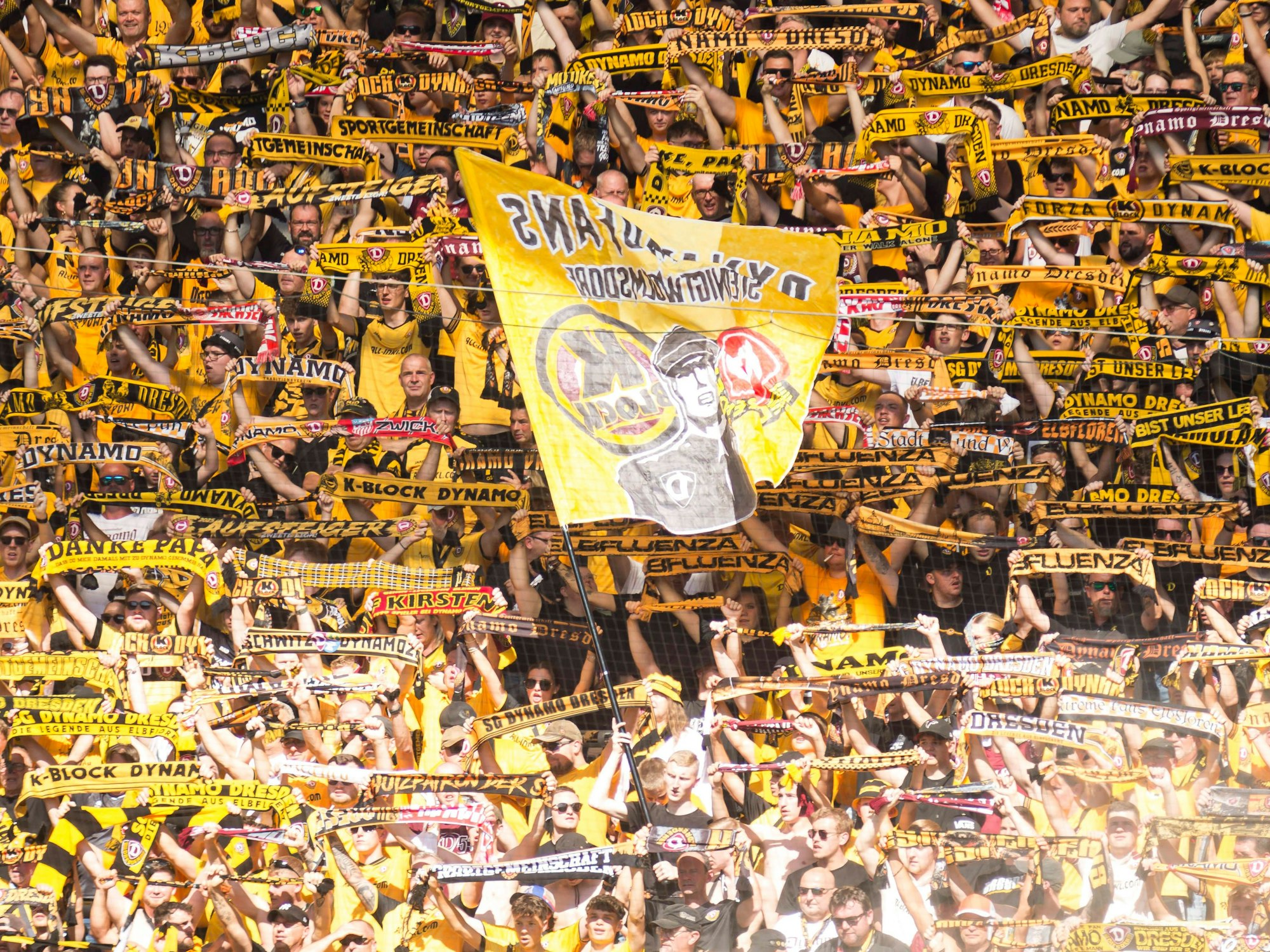 Dynamo-Fans halten im Gästeblock ihre Schals hoch.