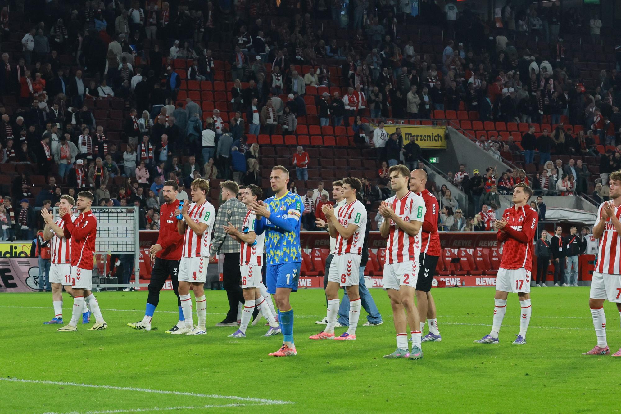 Die Spieler des 1. FC Köln sind enttäuscht und klatschen vor den Fans.