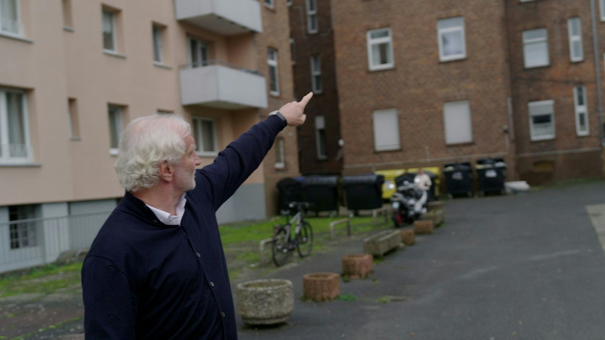 Die Lamboystraße in Hanau. Rudi Völler zeigt auf die Wohnung, in der er aufgewachsen ist. Die Eltern und der deutlich ältere Bruder sind bereits verstorben. Kurz nach dieser Szene gibt es Rudi-Rufe von der nahen Durchgangsstraße: „Hanauer Bub“ wird aus dem Auto liebevoll gegrölt. (Bild: © Sky/Banijay Productions Germany)