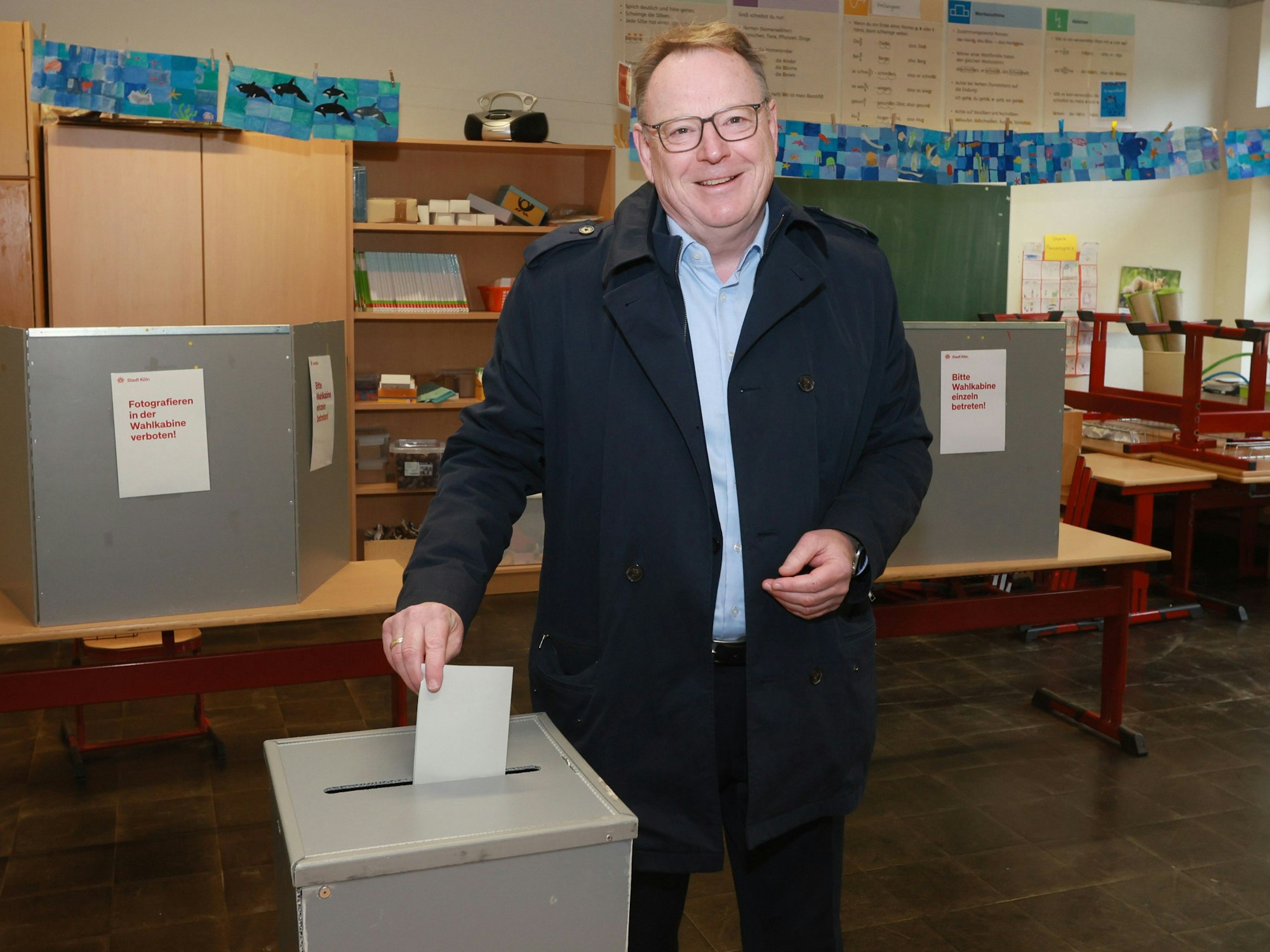 Ein Mann steckt einen Umschlag in eine Kiste mit Schlitz.