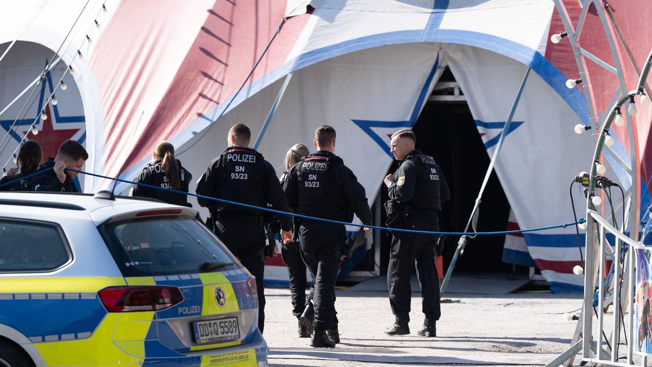 Polizisten und Polizistinnen gehen auf ein Zirkuszelt zu.