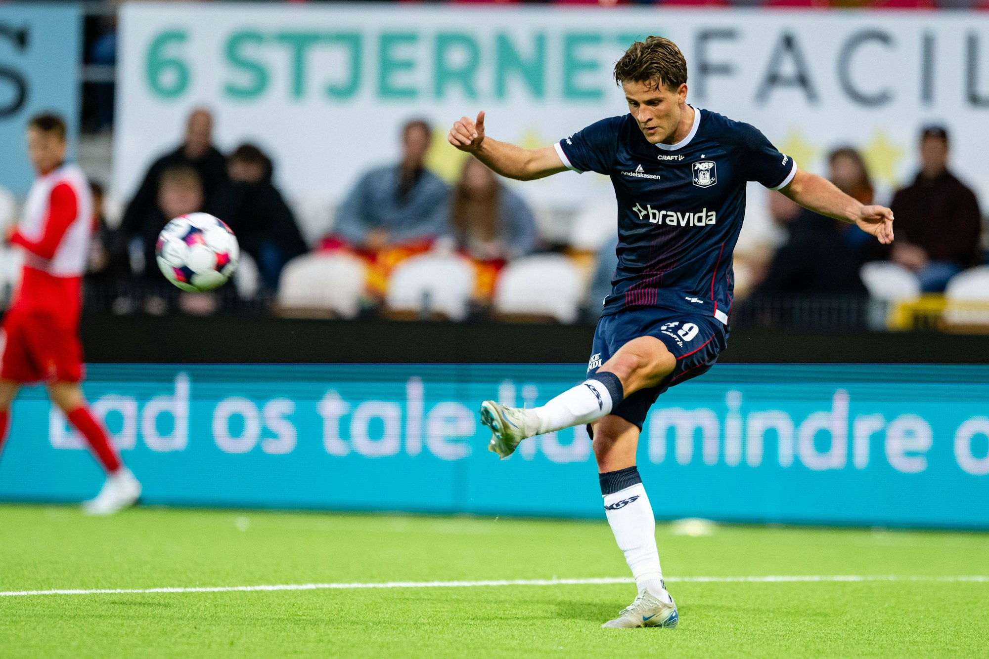 Rasmus Carstensen flankt einen Ball mit dem linken Bein.