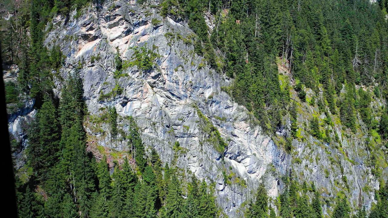 Blick auf eine steile Felswand in den Alpen.