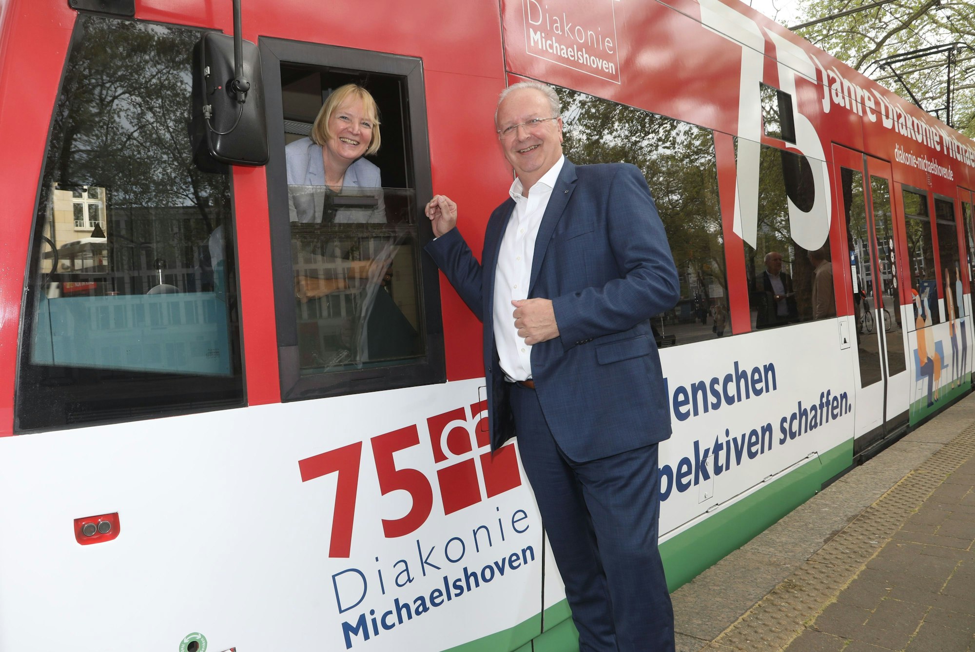 Uwe Ufer von der Diakonie Michaelshoven und KVB-Chefin Stefanie Haaks vor einer Stadtbahn.