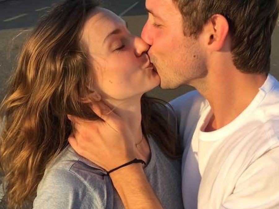 Ein junges Paar küsst sich auf der Straße.