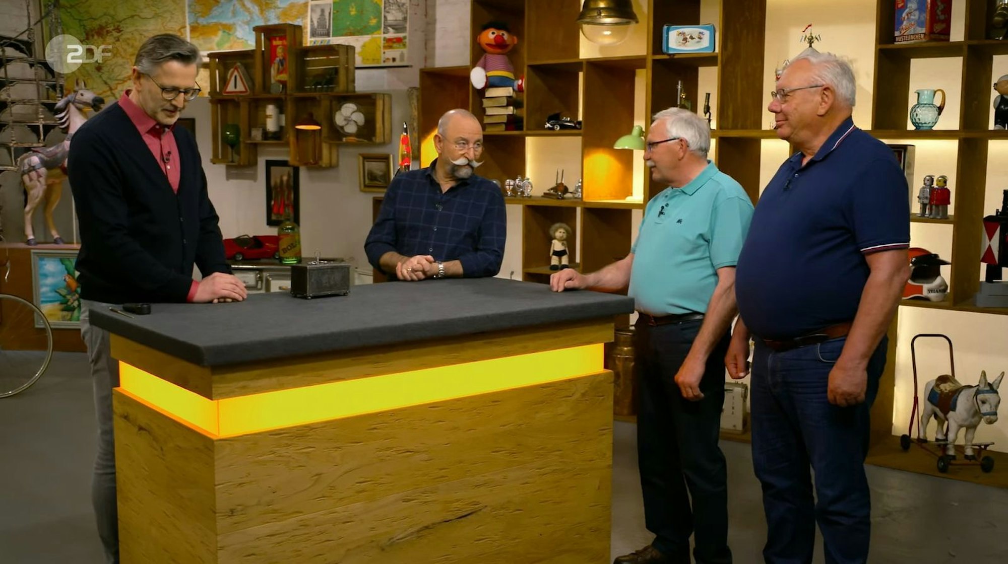 Die „Bares für Rares“-Kandidaten Siegfried (Zweiter von rechts) und Michael (rechts) zeigten Horst Lichter und Experte Detlev Kümmel (links) ein Objekt, das sich als Fälschung herausstellte. (Bild: ZDF)