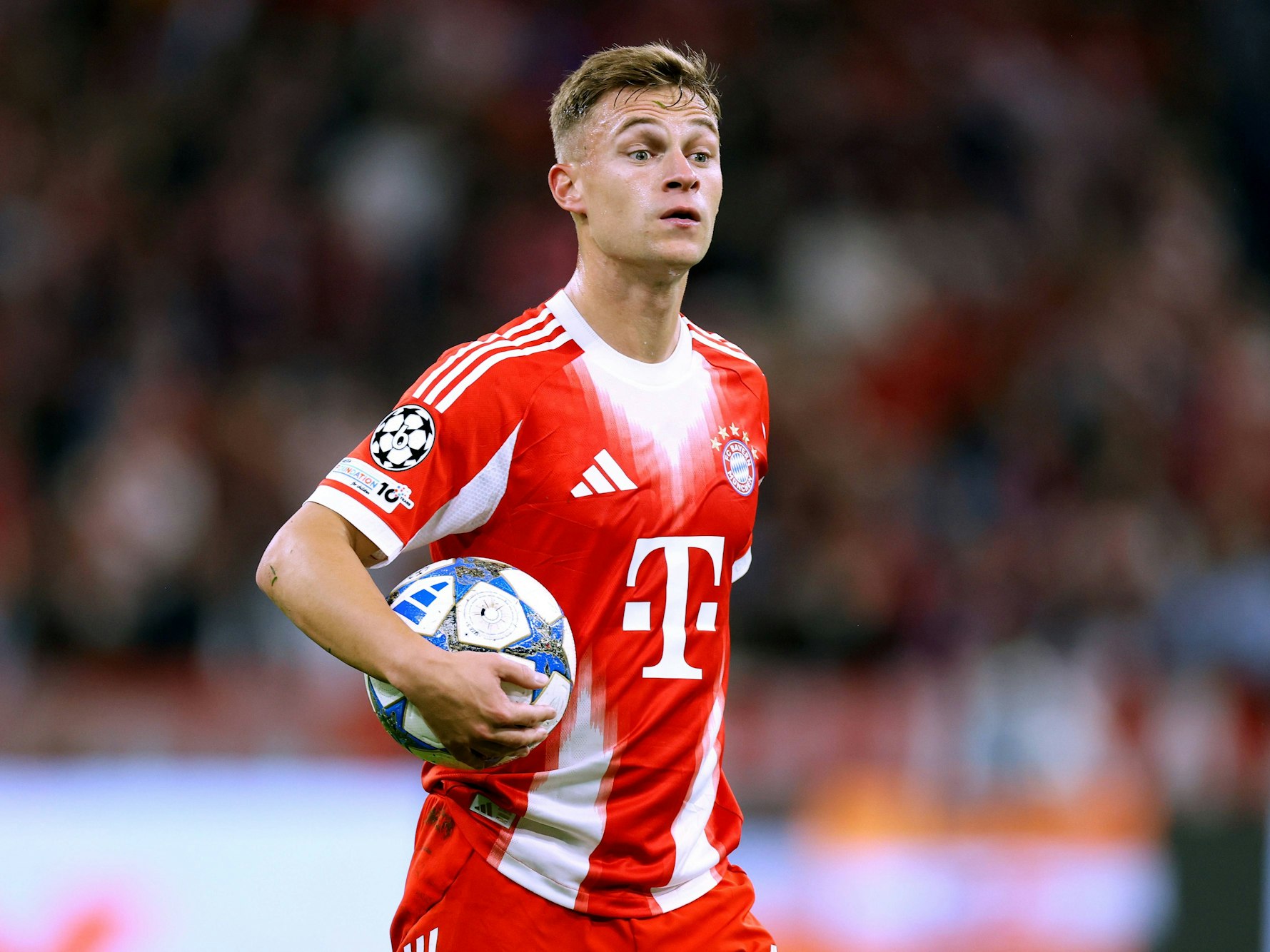 Joshua Kimmich hält den Ball in seinem Arm.