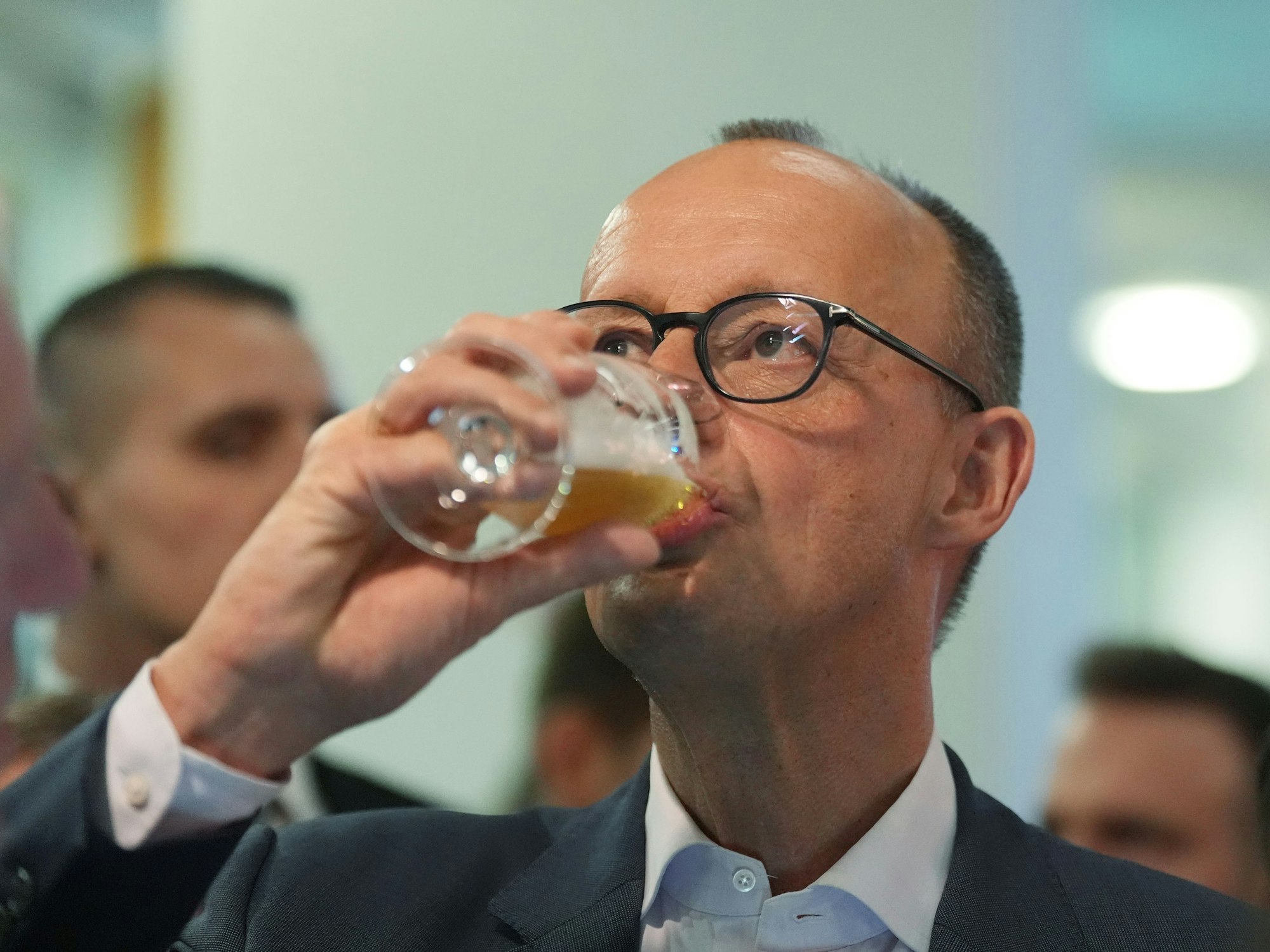 Friedrich Merz trinkt ein Bier.