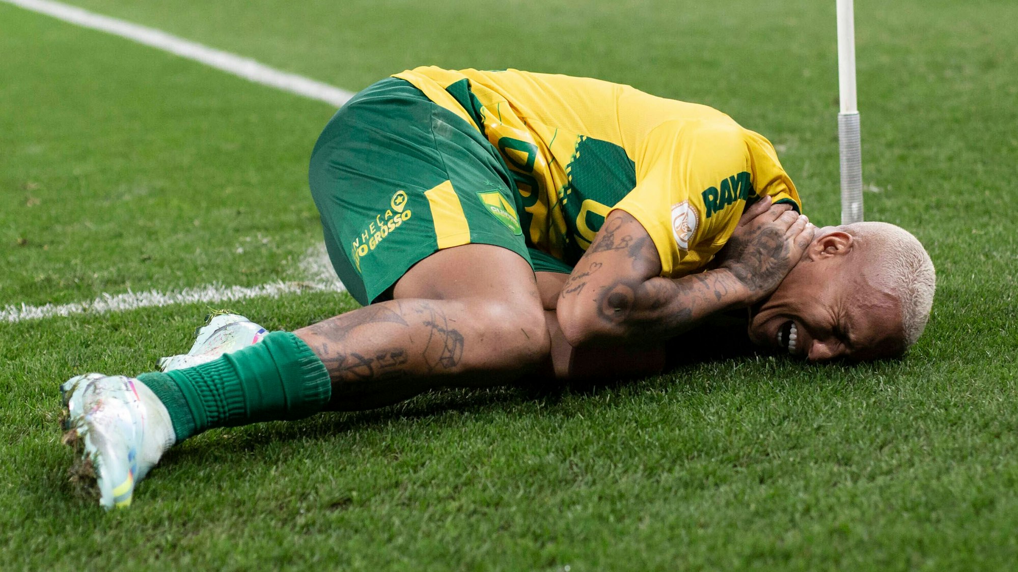 Deyverson liegt verletzt am Boden und hält sich mit schmerzverzerrtem Gesicht die Hand an den Nacken.