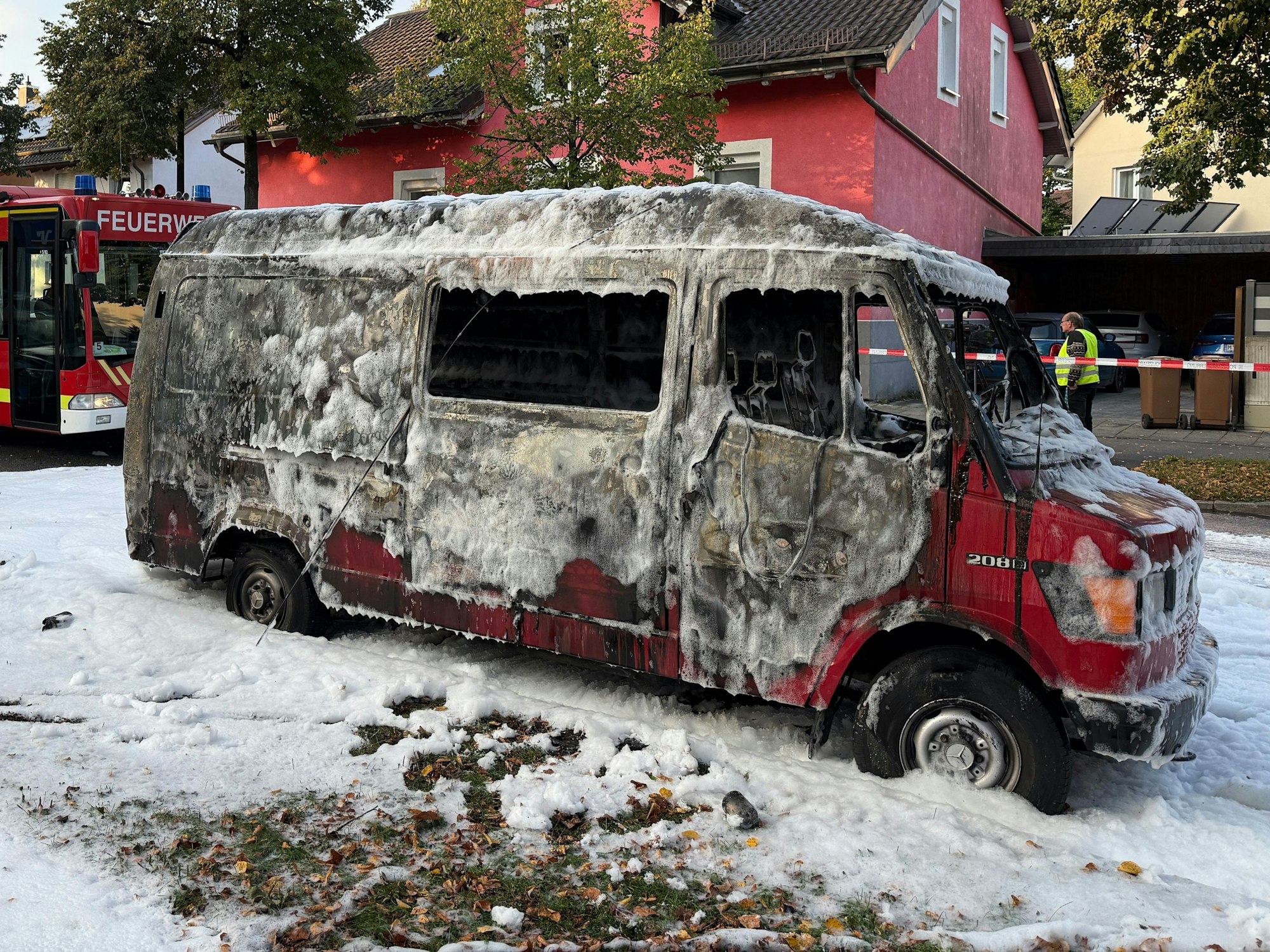 Ein ausgebrannter Mercedes-Transporter steht in München an der Straße.