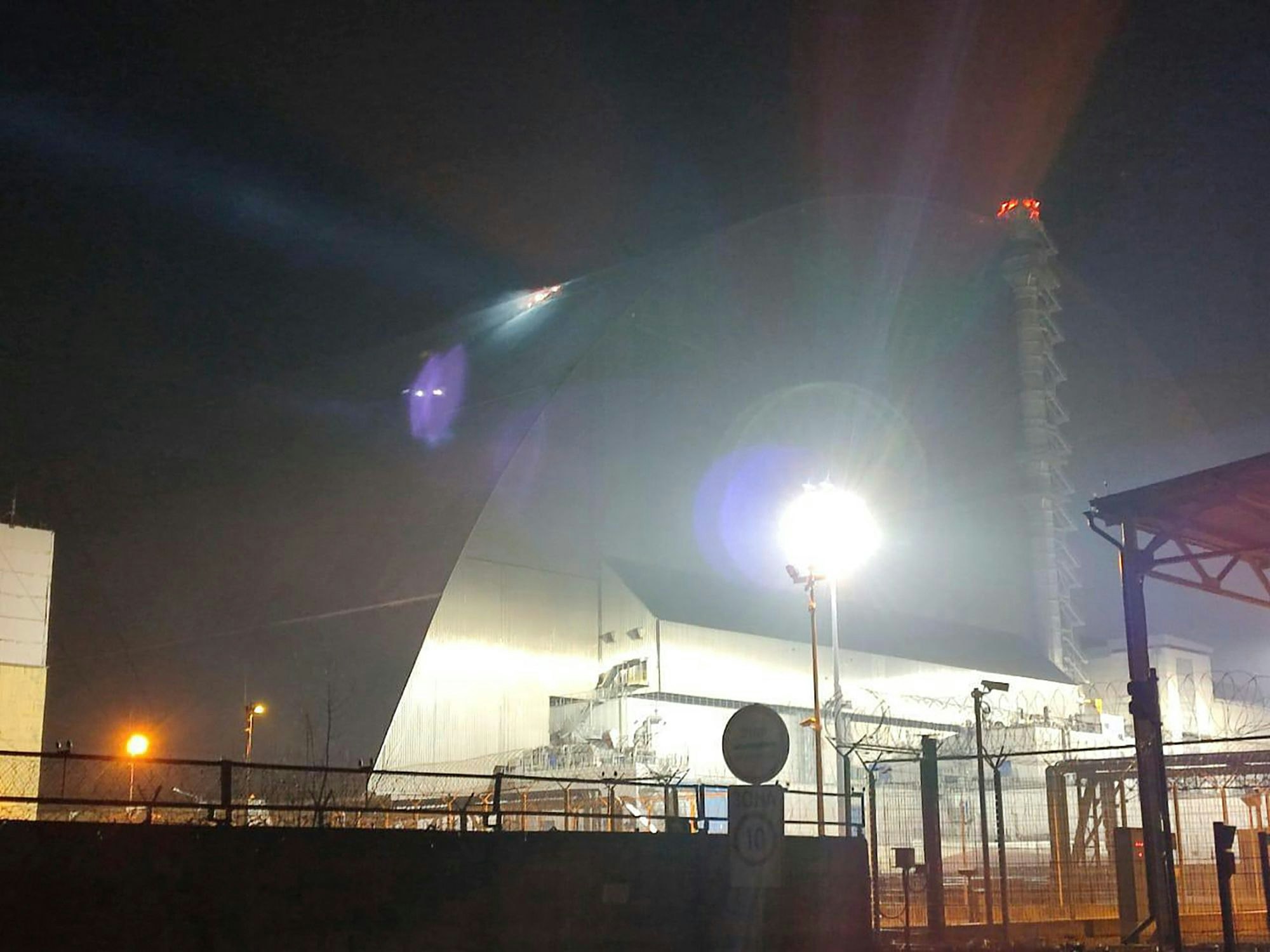 Auf diesem im Februar 2025 vom ukrainischen Katastrophenschutz via AP zur Verfügung gestellten Foto beleuchtet ein Suchscheinwerfer den Sarkophag des Kernkraftwerks Tschernobyl. Damals beschädigte ihn eine russische Drohne.