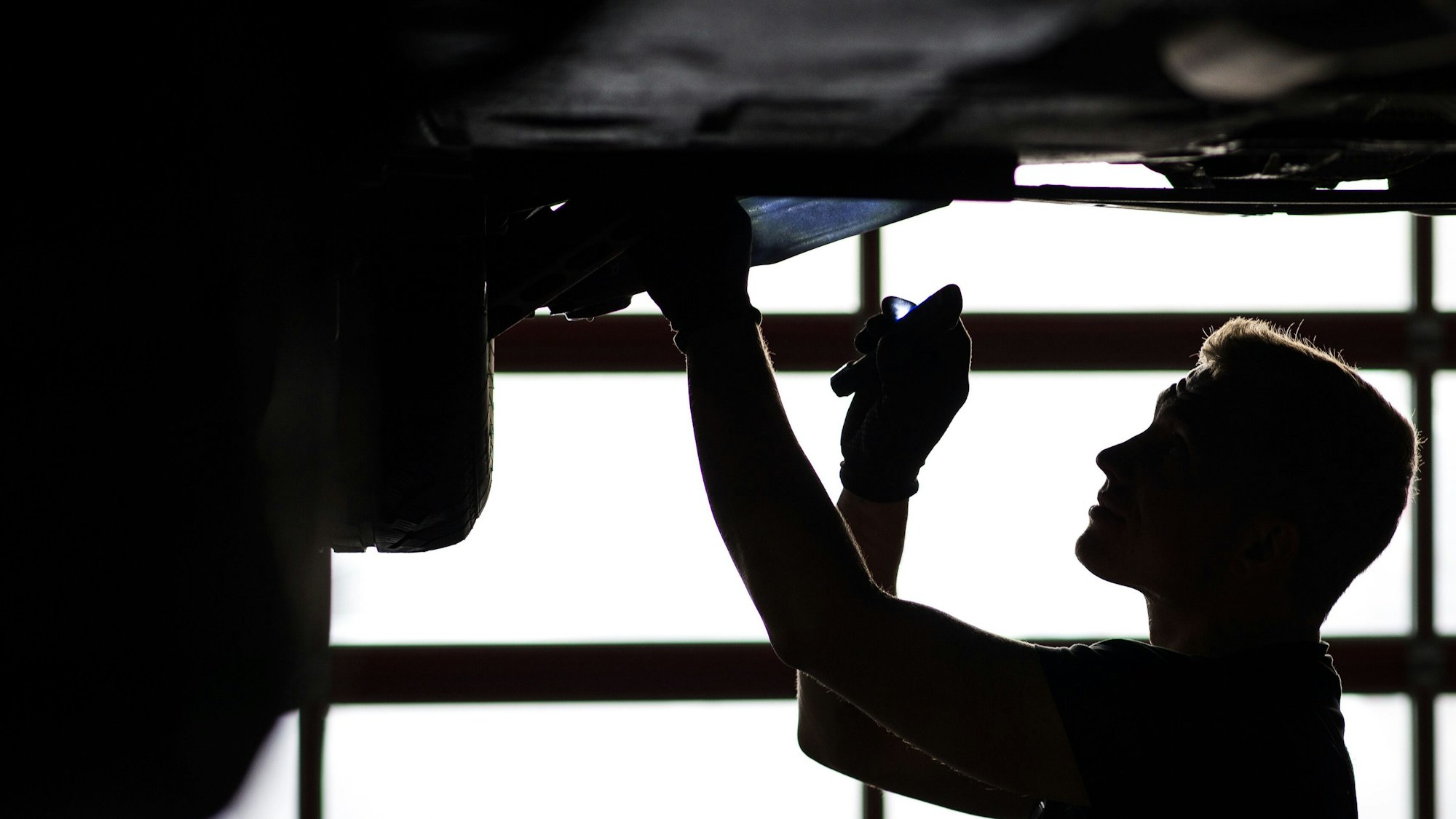 Ein Auto steht in einer Werkstatt auf der Hebebühne.