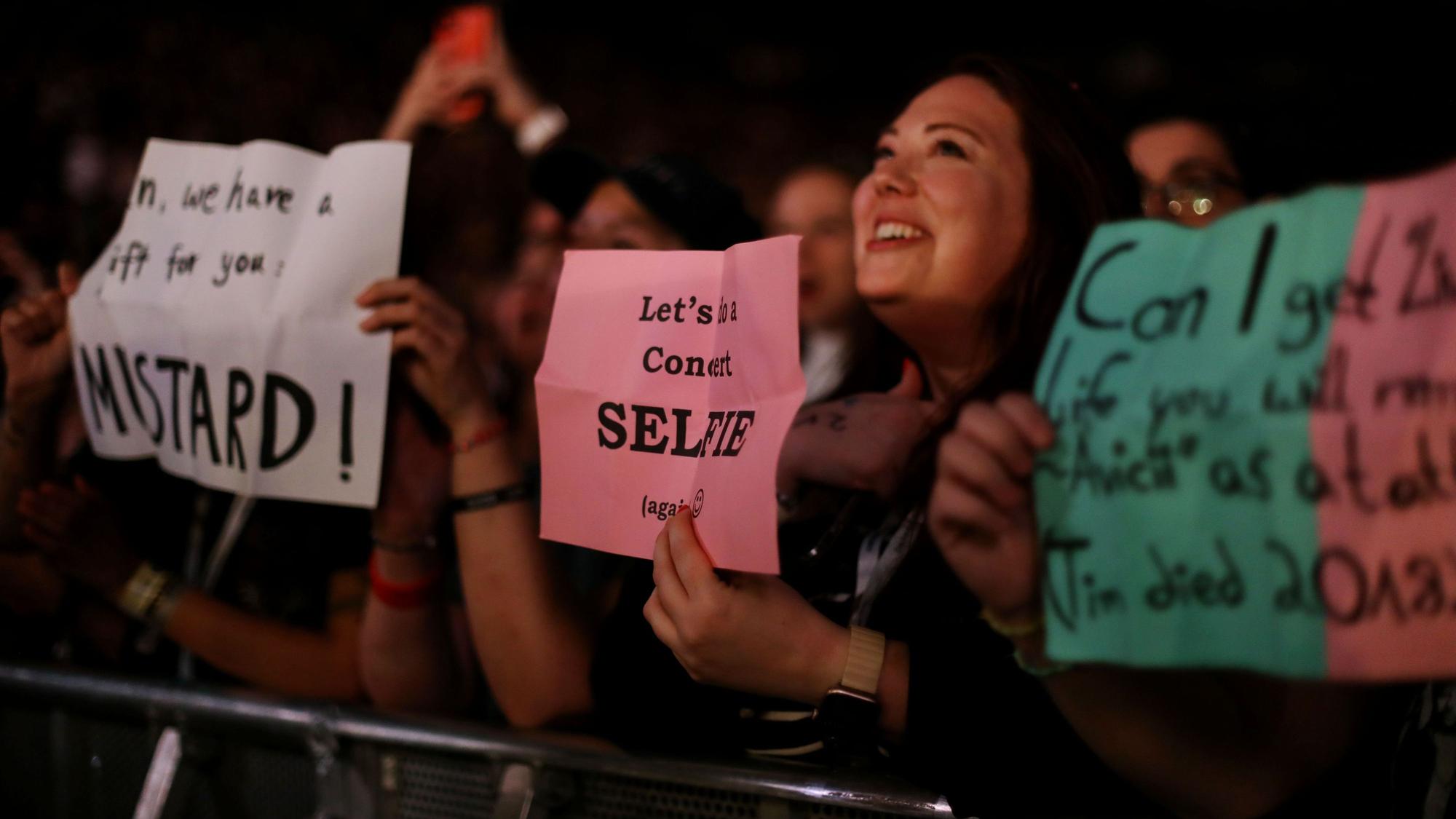 Fans halten Zettel für OneRepublic in der Lanxess-Arena hoch.