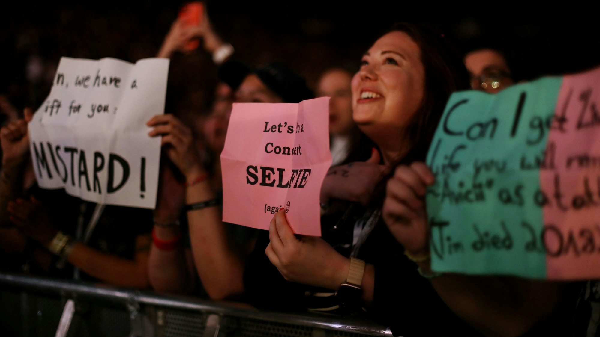 Fans halten Zettel für OneRepublic in der Lanxess-Arena hoch.