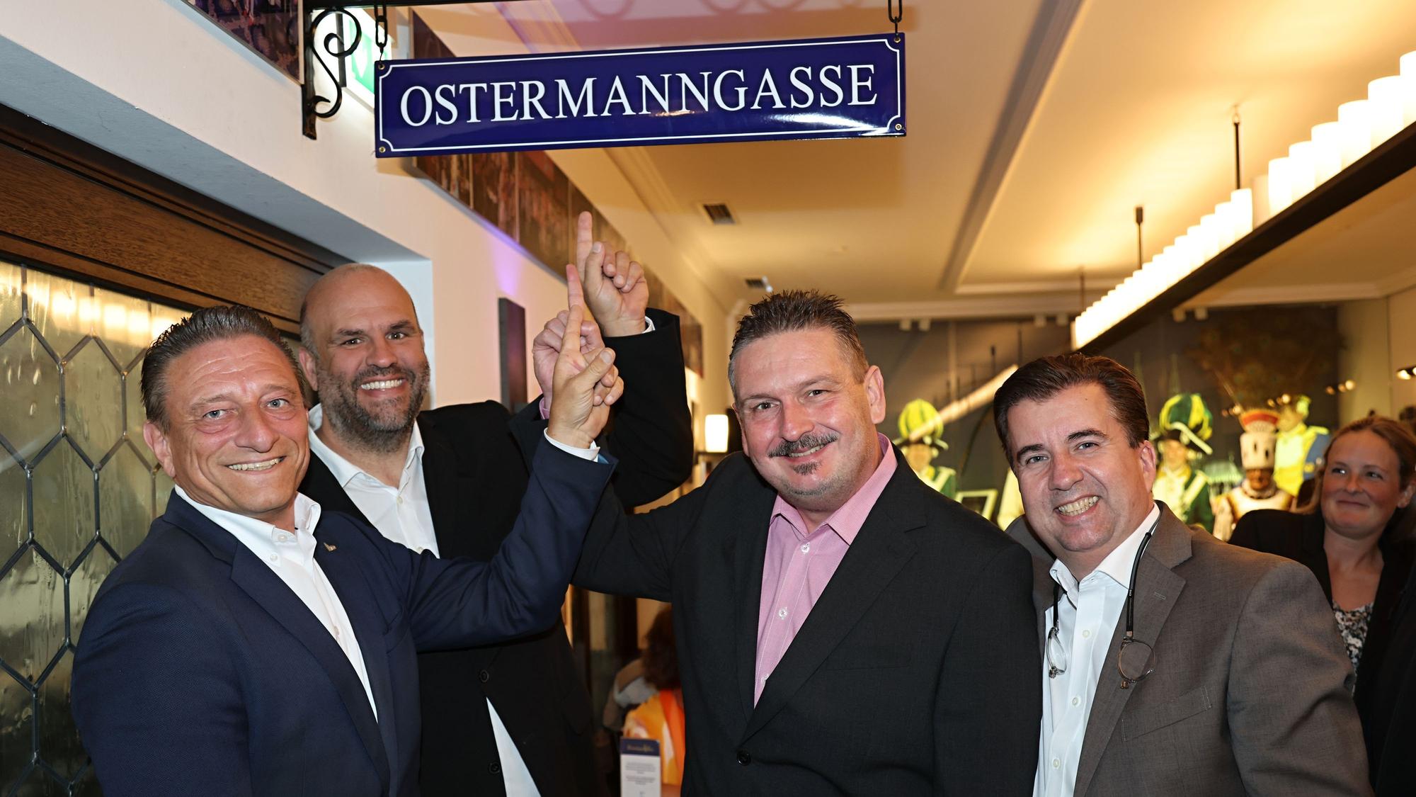 Marcus Schiffer, Jürgen Didschun, Björn Merklinghaus und Klaus Boddin zeigen auf das Schild zur Ostermanngasse.