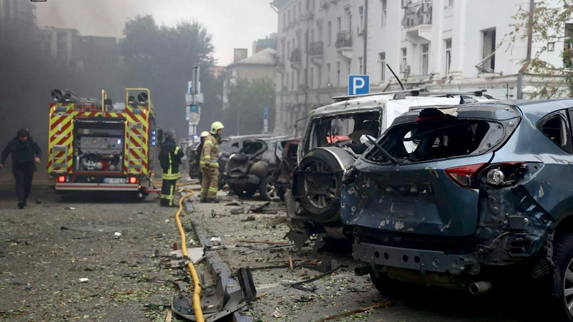 Feuerwehrleute löschen ein Feuer nach einem russischen Drohnenangriff in Dnipro. Mehrere Pkw brannten dabei aus.