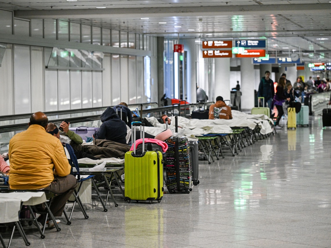 Menschen warten auf Feldbetten. Wegen einer Drohnensichtung sind am Flughafen in München am Donnerstagabend mehrere Flüge ausgefallen.