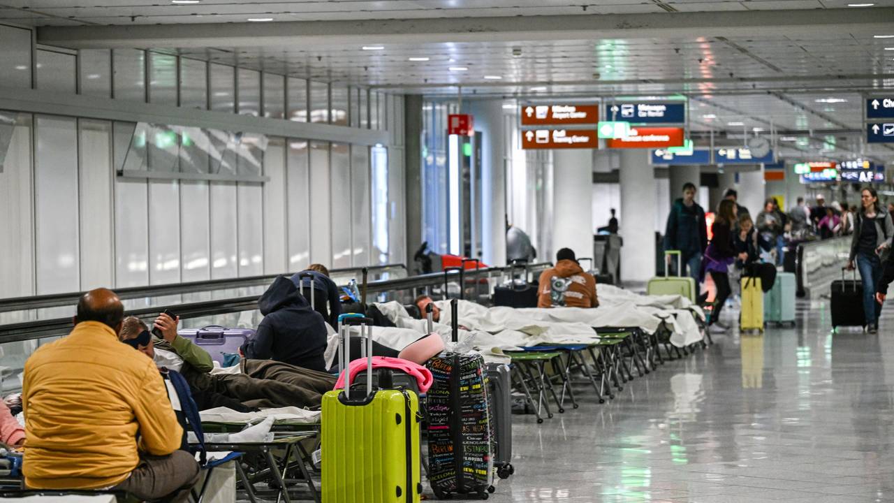 Menschen warten auf Feldbetten. Wegen einer Drohnensichtung sind am Flughafen in München am Donnerstagabend mehrere Flüge ausgefallen.