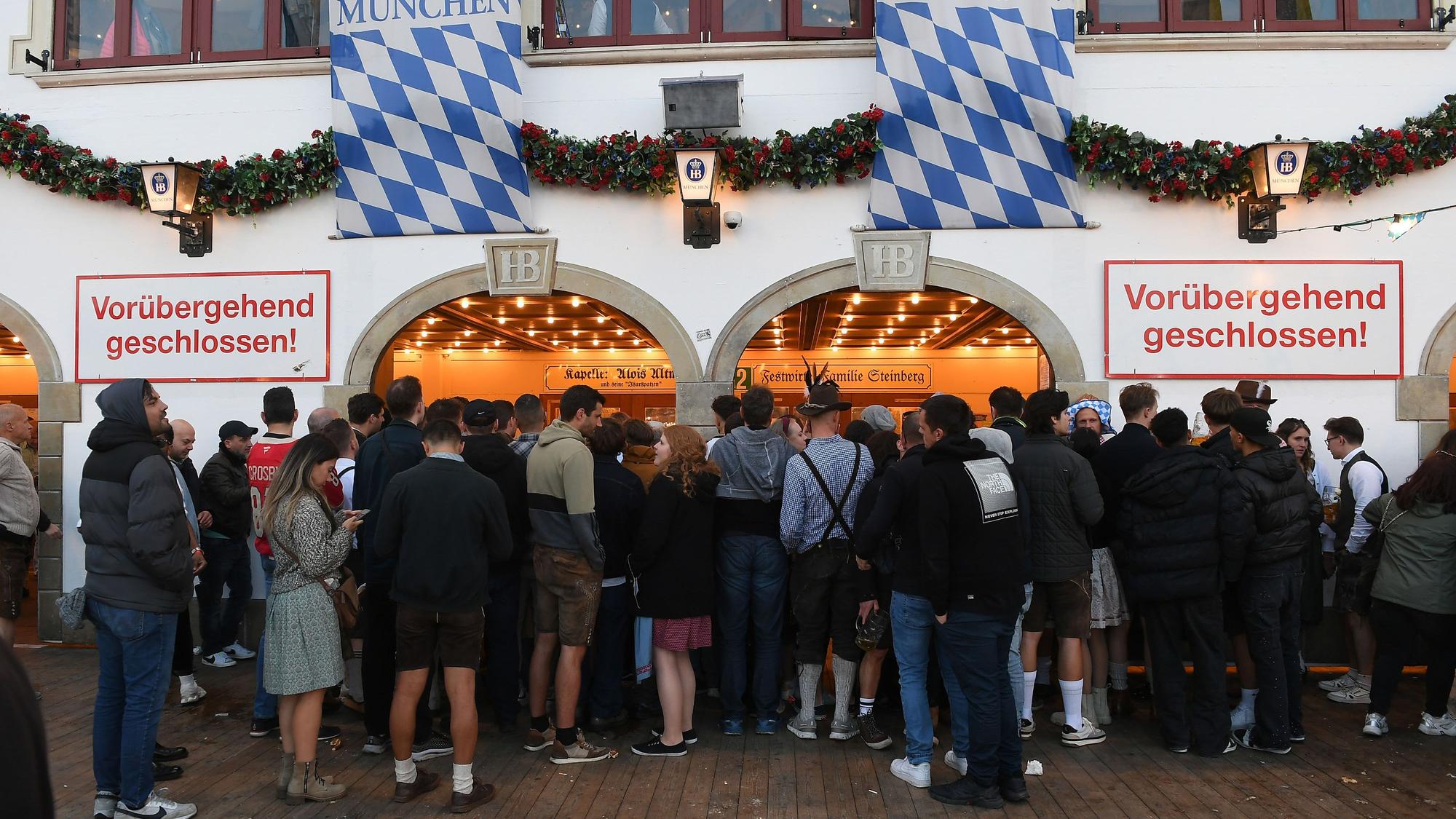 „Vorübergehend geschlossen“ steht am Eingang des Hofbräuzelt, vor dem zahlreiche Menschen stehen.