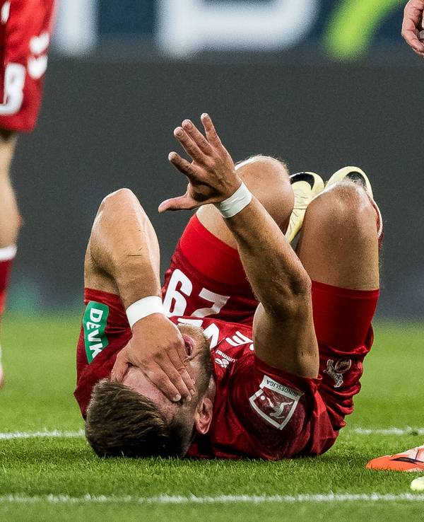 Jan Thielmann (1. FC Köln) bleibt nach Foul auf dem Rasen liegen.