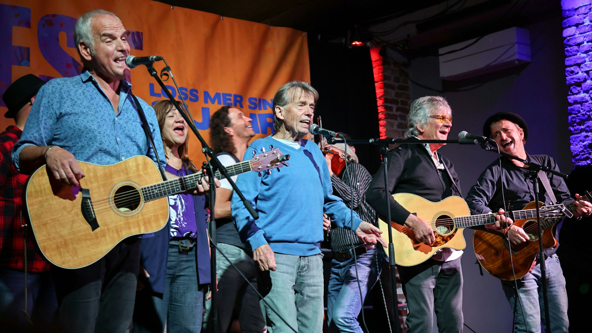 Musikerinnen und Musiker stehen beim Jubiläum von „Loss mer singe“ auf der Bühne.