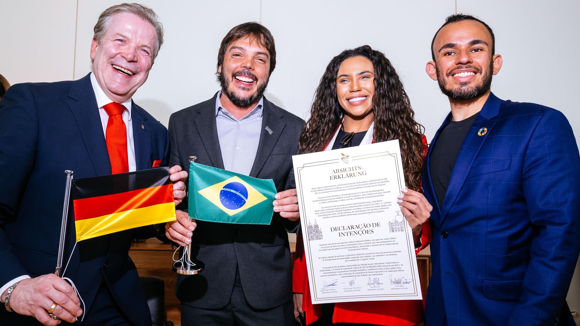 Christoph Kuckelkorn mit Eduardo Araujo „Dudu Menor“, Evelyn Bastos und Daniel Calarco zeigen den Partnerschaftsvertrag.