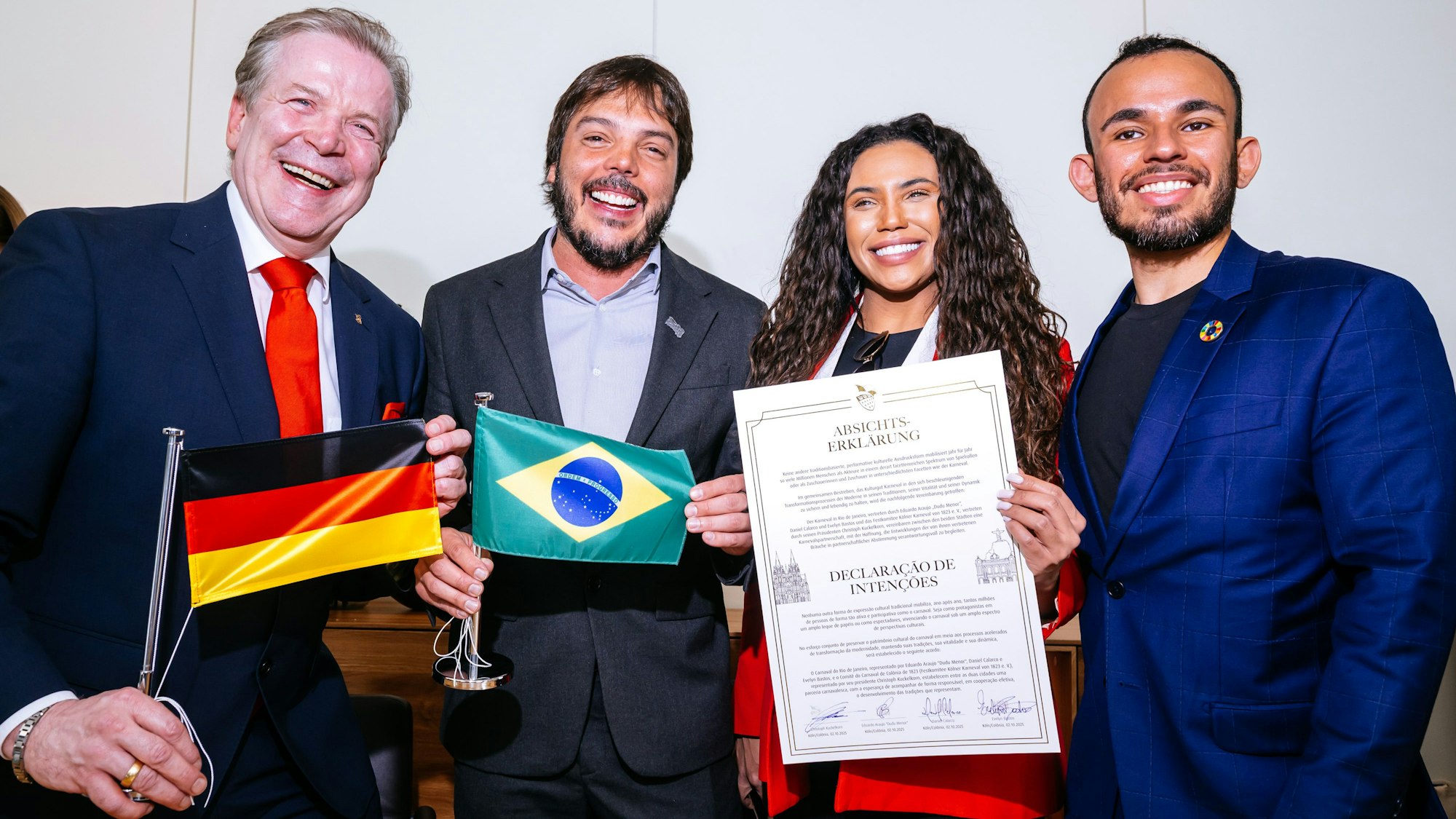 Christoph Kuckelkorn mit Eduardo Araujo „Dudu Menor“, Evelyn Bastos und Daniel Calarco zeigen den Partnerschaftsvertrag.