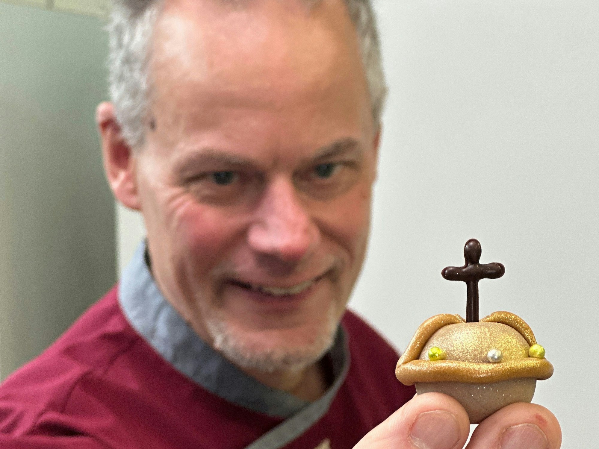 Marcel Seeger hält ein Plätzchen in die Kamera.