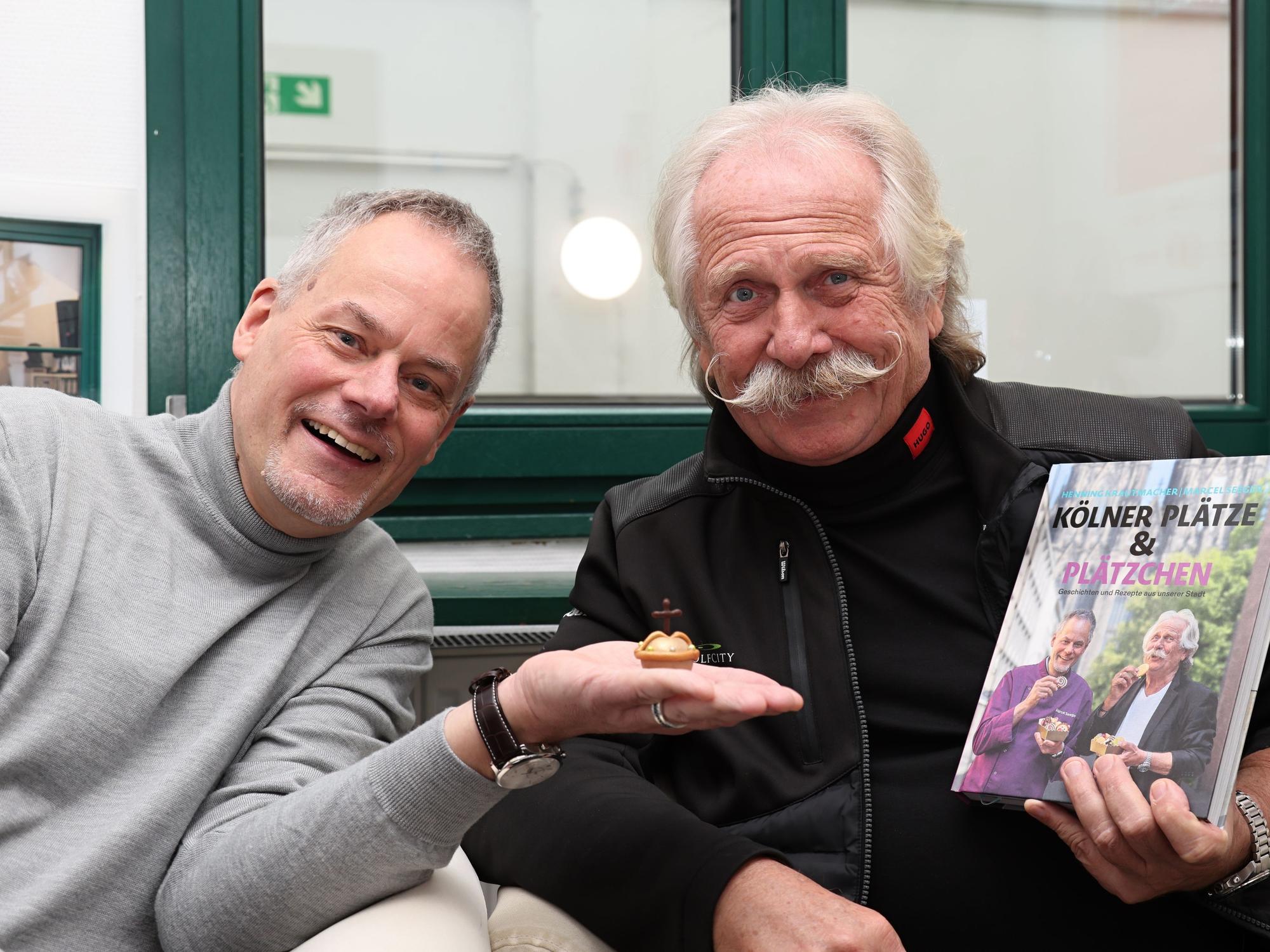 Henning Krautmacher und Marcel Seeger zeigen ihr Buch.