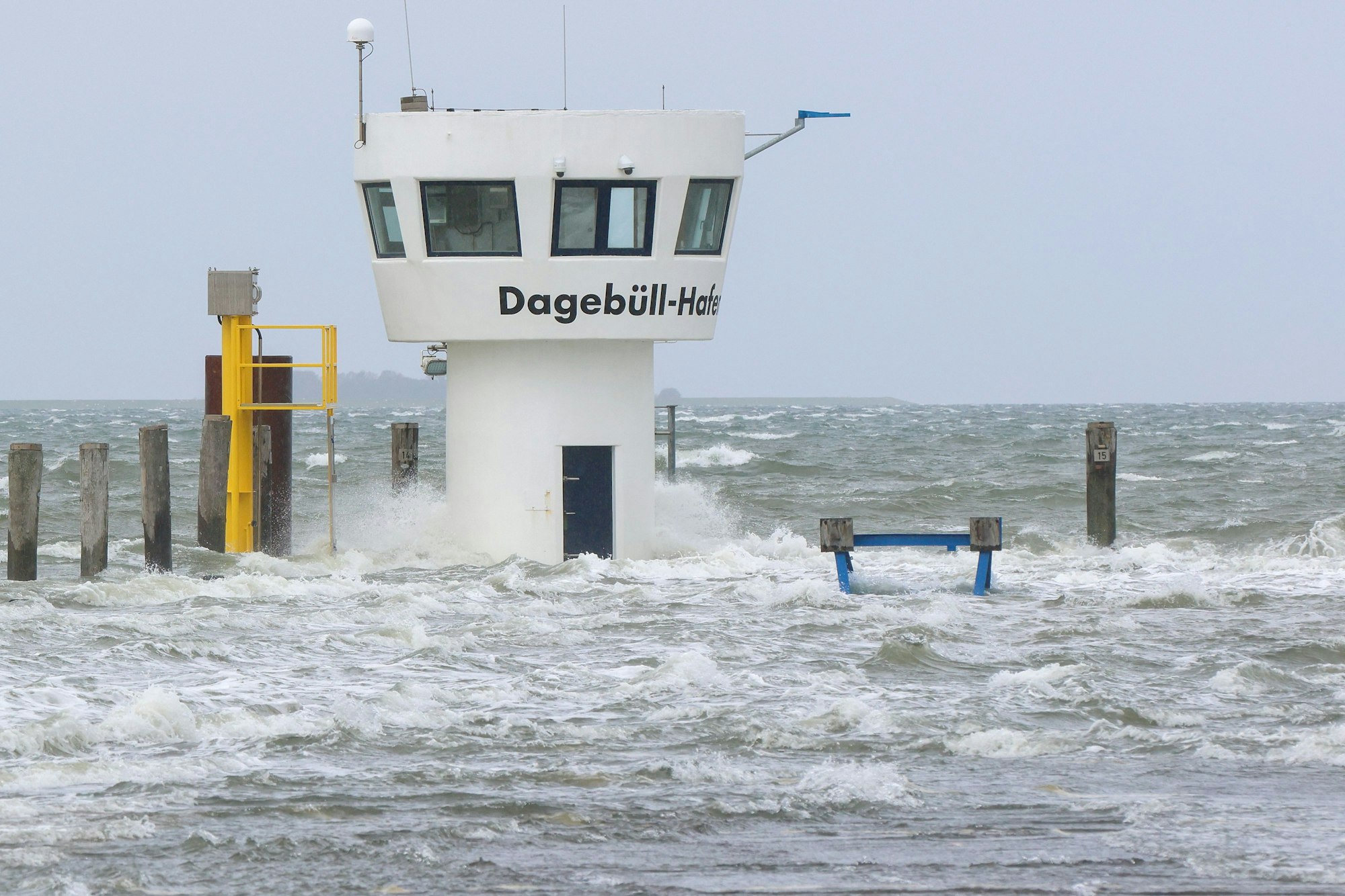 Wellen schlagen an einen Kontrollturm im Hafen. Teile des Fährhafens von Dagebüll werden bei einer Sturmflut überflutet.