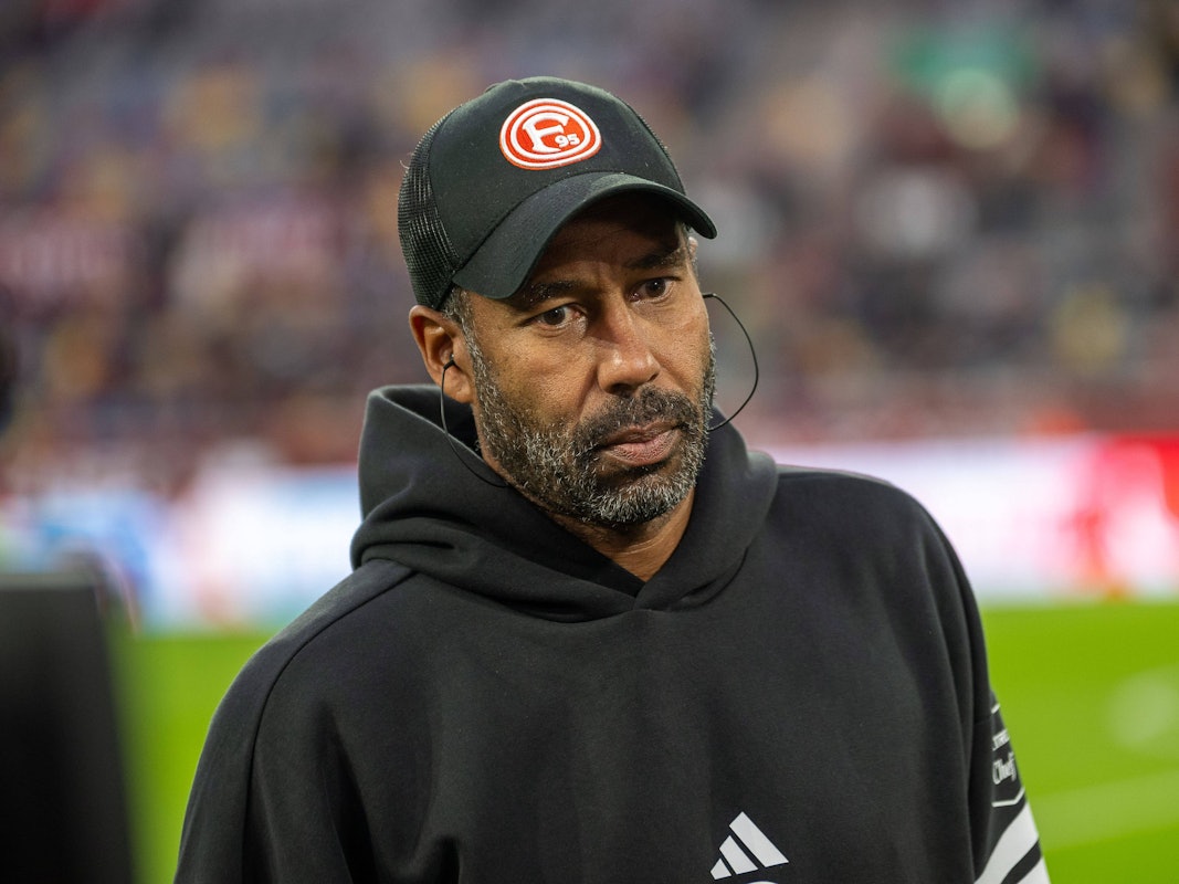 Daniel Thioune schaut mit leerem Blick an der Kamera vorbei ins Nichts.