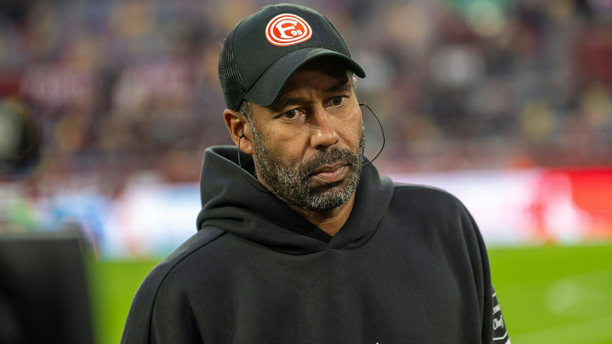 Daniel Thioune schaut mit leerem Blick an der Kamera vorbei ins Nichts.