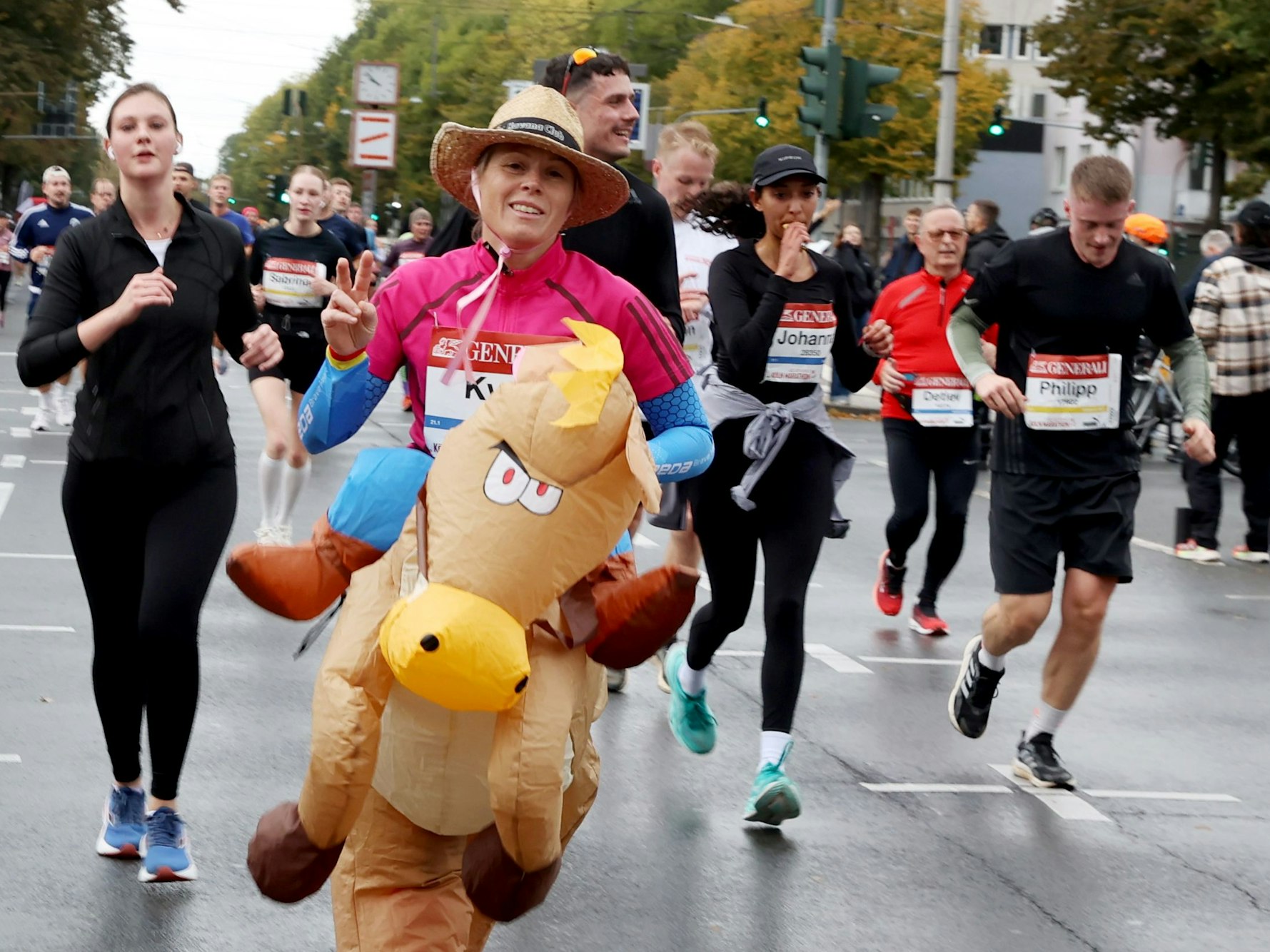 Eine Frau ist als Pferd verkleidet und läuft beim Köln-Marathon mit.