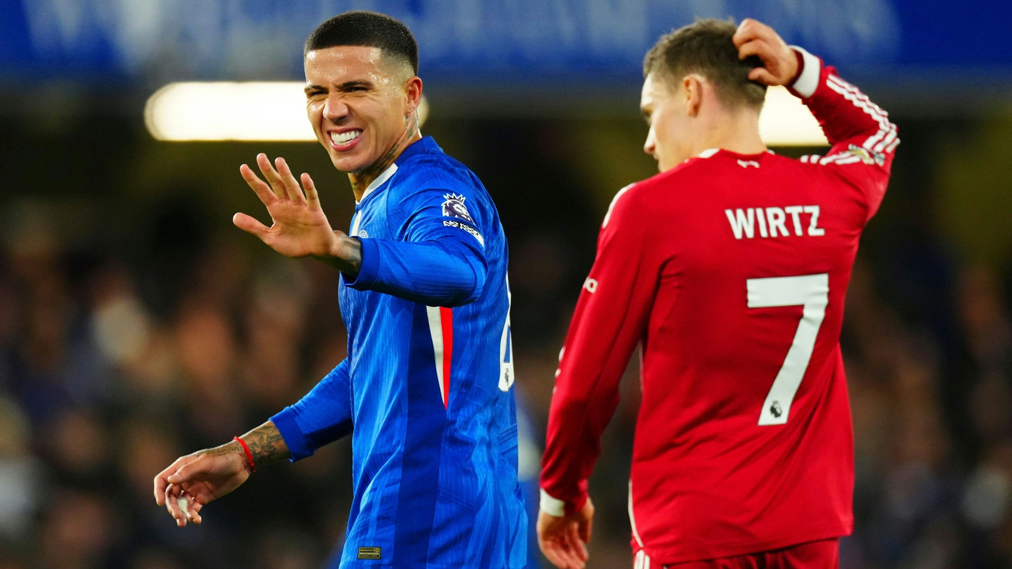 Enzo Fernandez (Chelsea) macht eine Geste, Florian Wirtz (Liverpool) kratzt sich nachdenklich am Kopf.